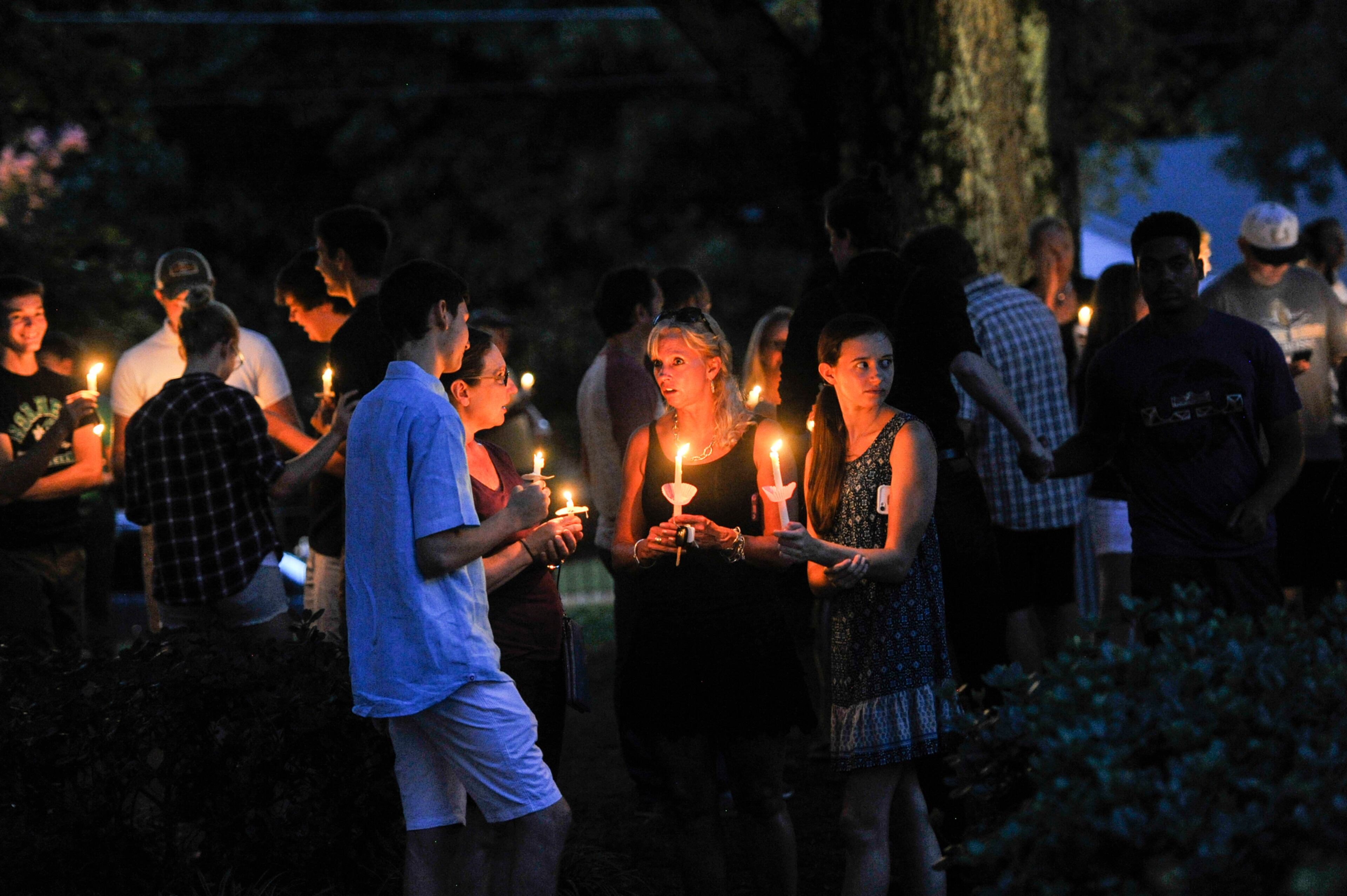 Friends of Natalie Henderson hug during a vigil held for her on the old Roswell Square, Thursday, Aug. 4, 2016. Henderson, of Roswell and Carter Davis of Woodstock, both 17, were found Monday behind a Publix grocery store shot to death. Jeffrey A. Hazelwood, 20, was arrested Wednesday and will be charged with two counts of murder in the deaths. (Photo Contributed by John Amis)