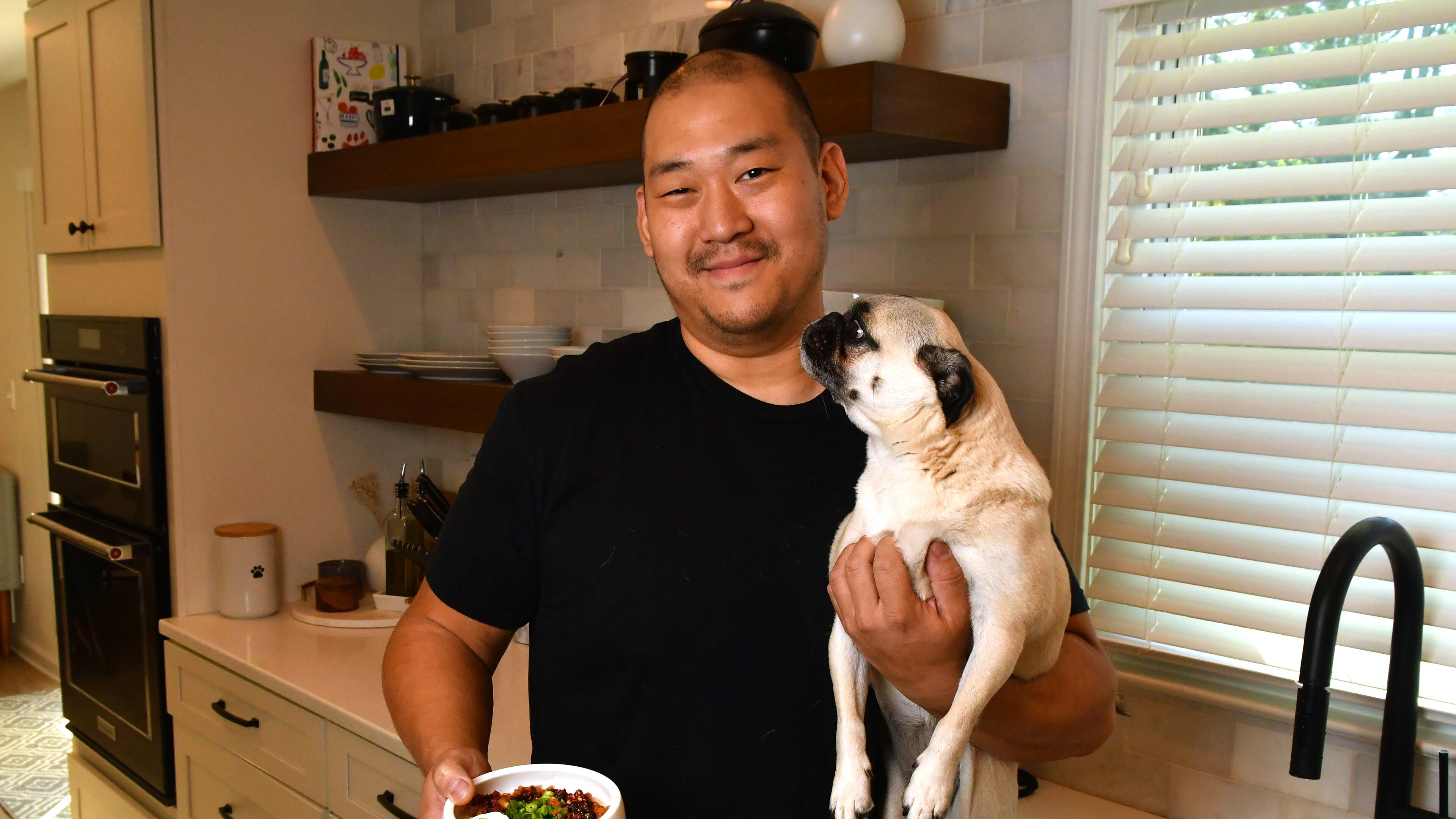James Beard Award-nominated Brian So of Spring restaurant hangs out with one of his favorite pugs, Freddie. When So cooks for himself, his food leans toward Korean, the cuisine he grew up eating at home in Kennesaw. (CHRIS HUNT FOR THE ATLANTA JOURNAL-CONSTITUTION)