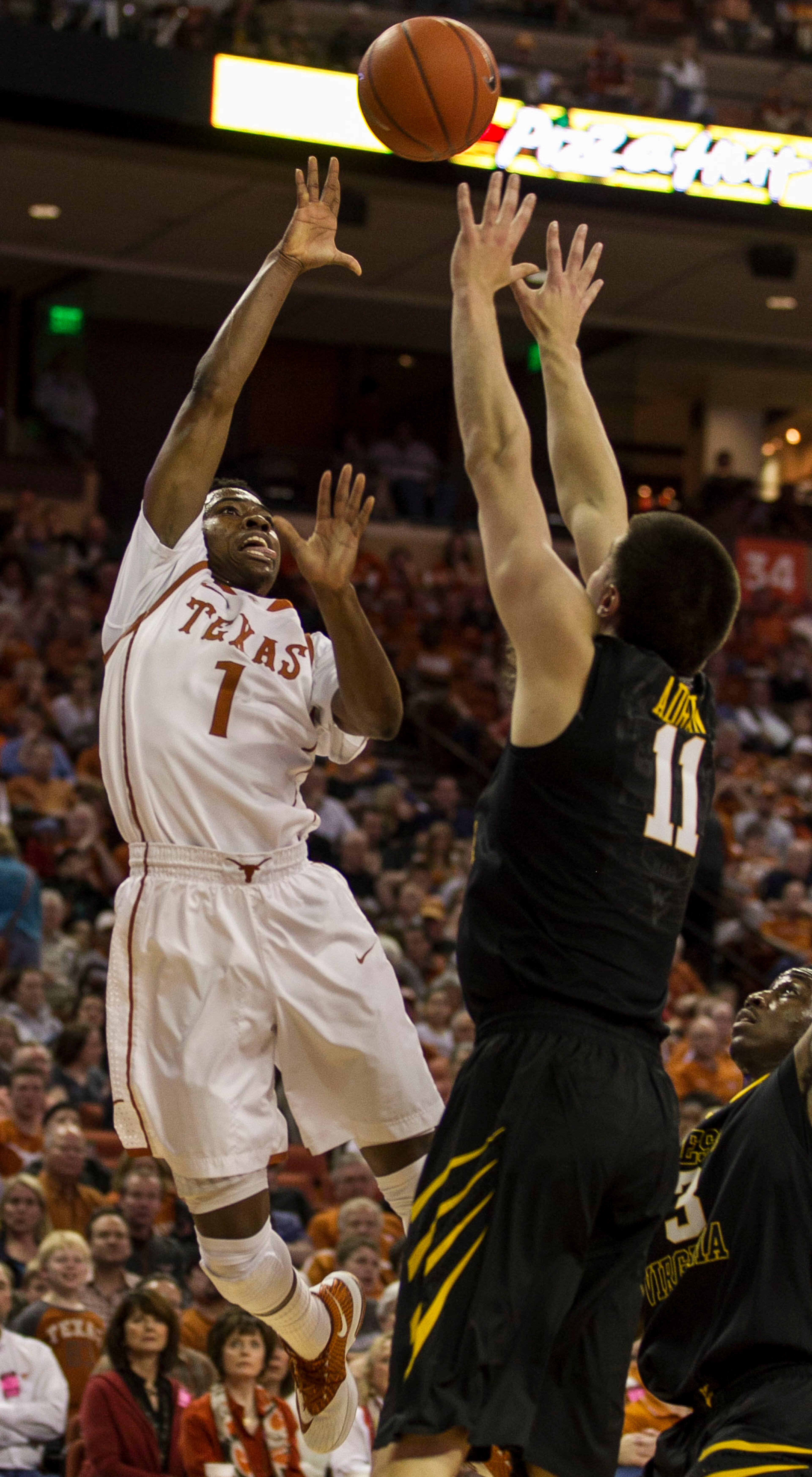 Texas #1, Isaiah Taylor gets a running jumper over West Virginia #11, Nathan Adrian, right, during Big 12 action held at the Frank Erwin Center in Austin, Texas, on Saturday, February 15, 2014.