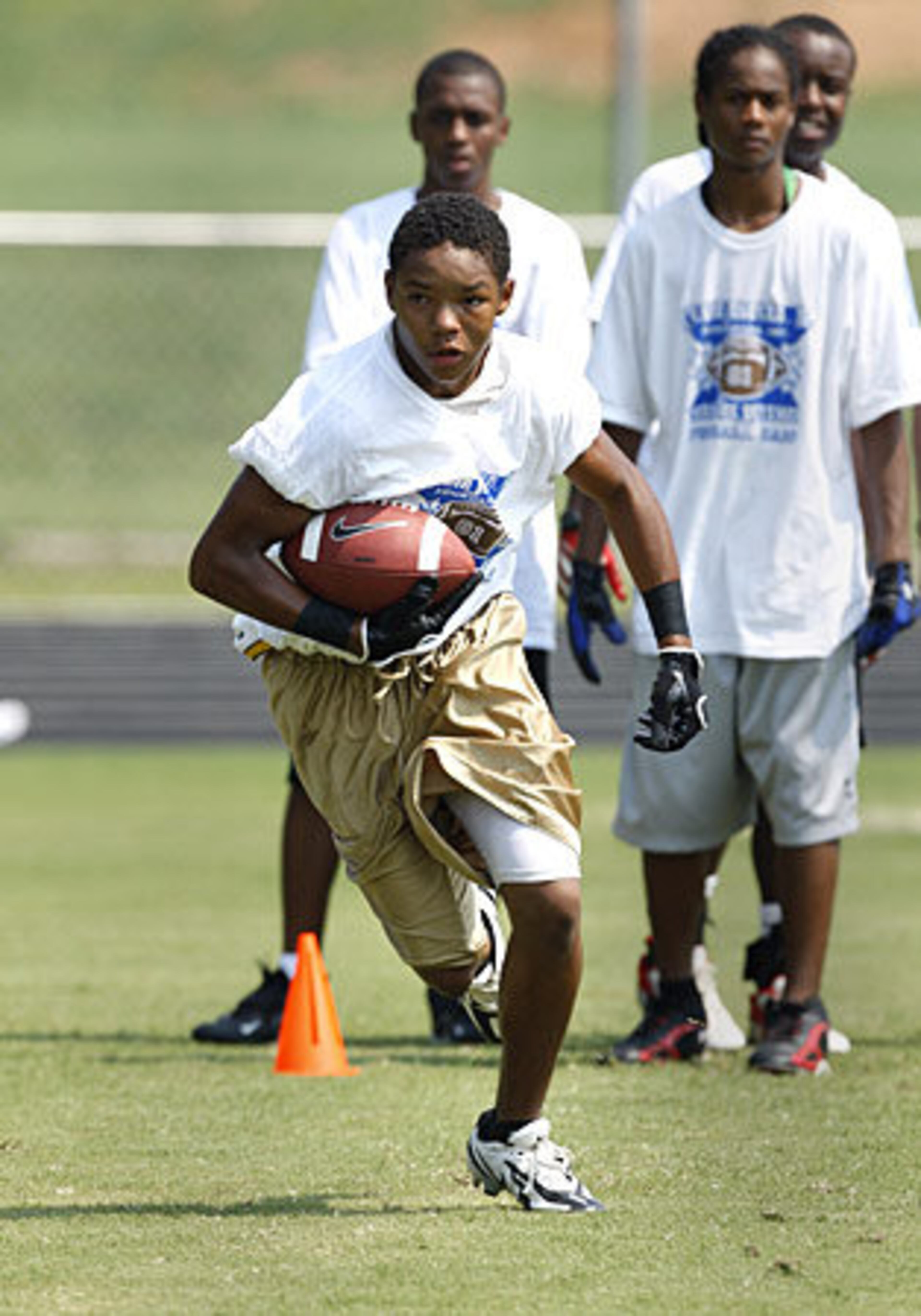 Woodward Academy's Ryan Dillard, 14, shows off his running skills during NFL Detroit Lions and former Georgia Tech star wide receiver Calvin Johnson Jr.'s 2008 Wide Receiver Camp in Tyrone, Ga. Dillard's father, Oscar, is a former high school coach who runs his own football academy and charges $50 per session and $250 for three-day camps.