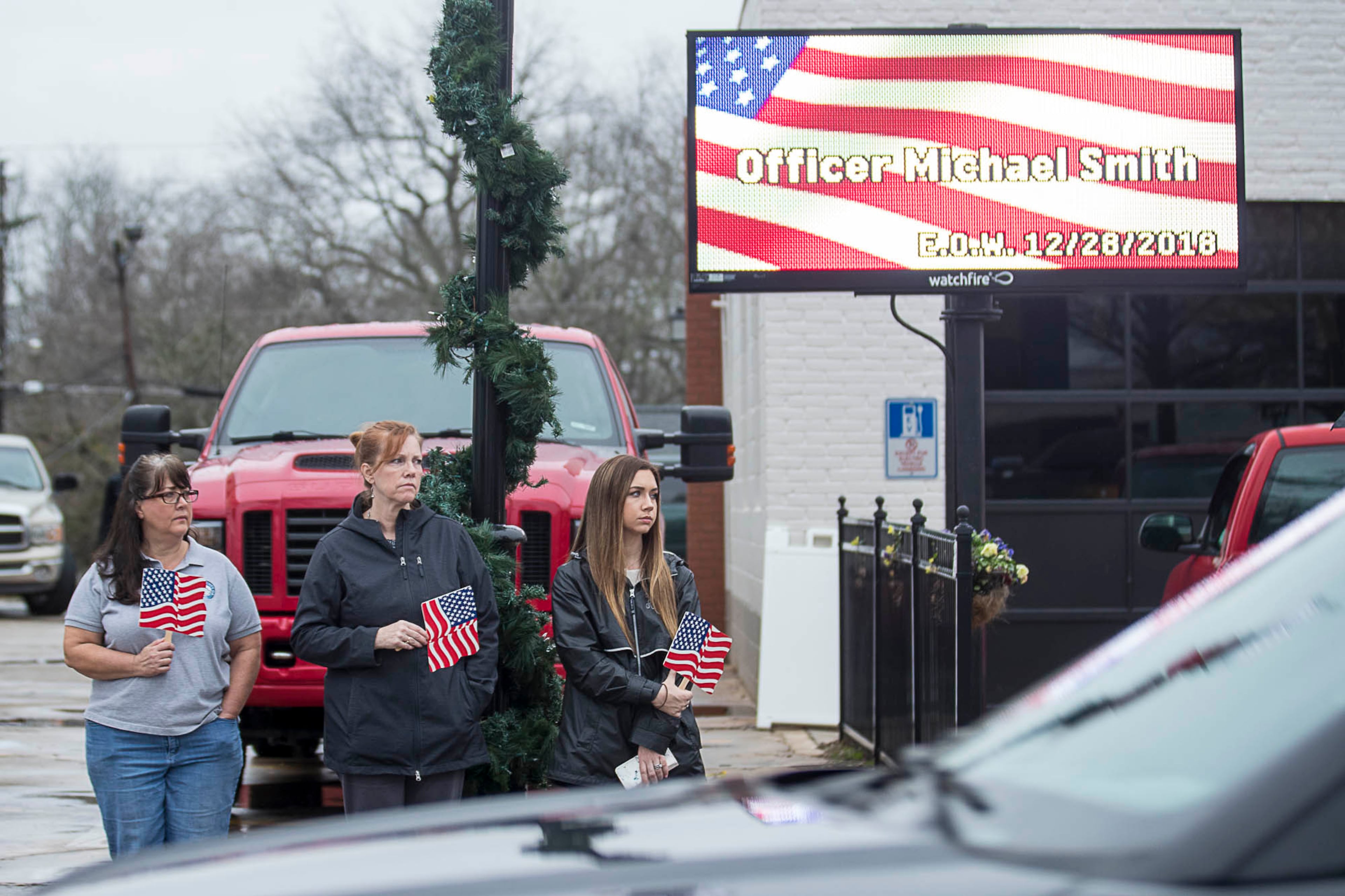01/03/2019 -- McDonough, Georgia -- Supporters of slain Henry County Police Officer Michael Smith watch as the funeral procession travels through McDonough Squared in McDonough, Thursday, January 3, 2019. Henry County police Officer Michael Smith died from injuries from a gunshot wound he received while responding to a report of a irate man at a McDonough-area dental office. (ALYSSA POINTER/ALYSSA.POINTER@AJC.COM)