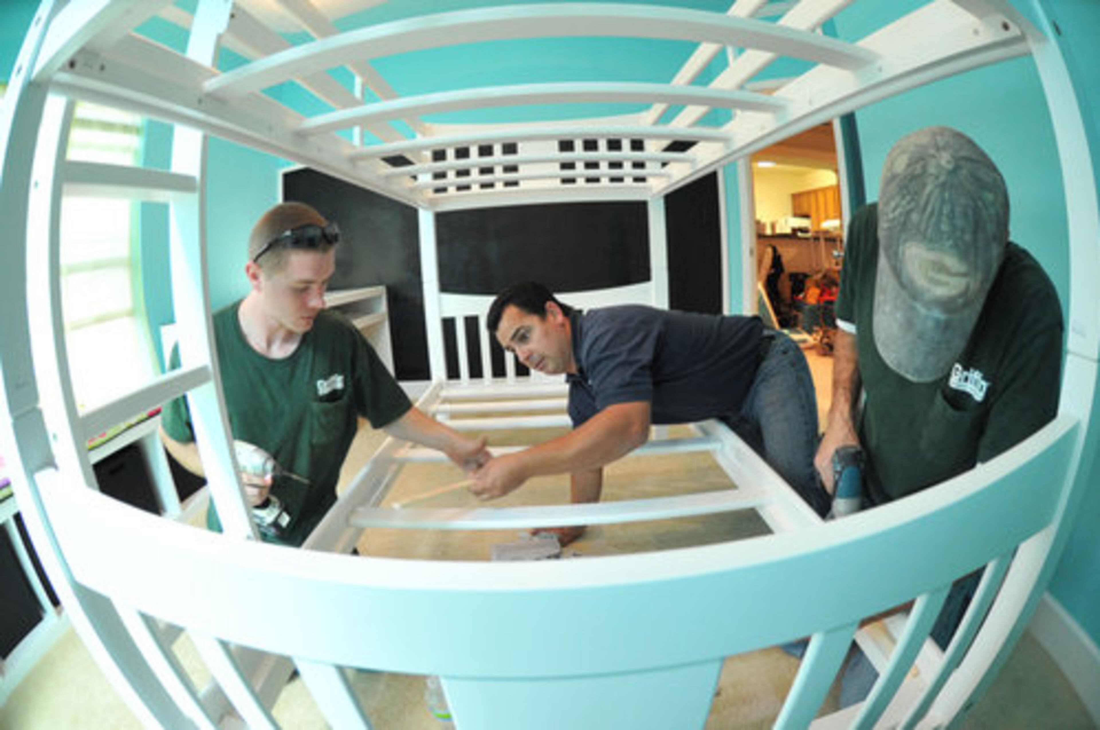 TEEN BEDROOM MAKEOVER--From left, Justin Nave, Robert Lucero, and Michael Durden, all from R.J. Griffin & Company, put up a bedstead at a selected student's room for an Xtreme Bedroom Makeover competition on Saturday, Dec. 4, 2010. The Ron Clark Academy, for third year in a row, works with its sponsors and volunteer organizations to conduct the competition. Each organization that has chosen to participate is responsible for renovating the bedroom of one of RCA's students in need.