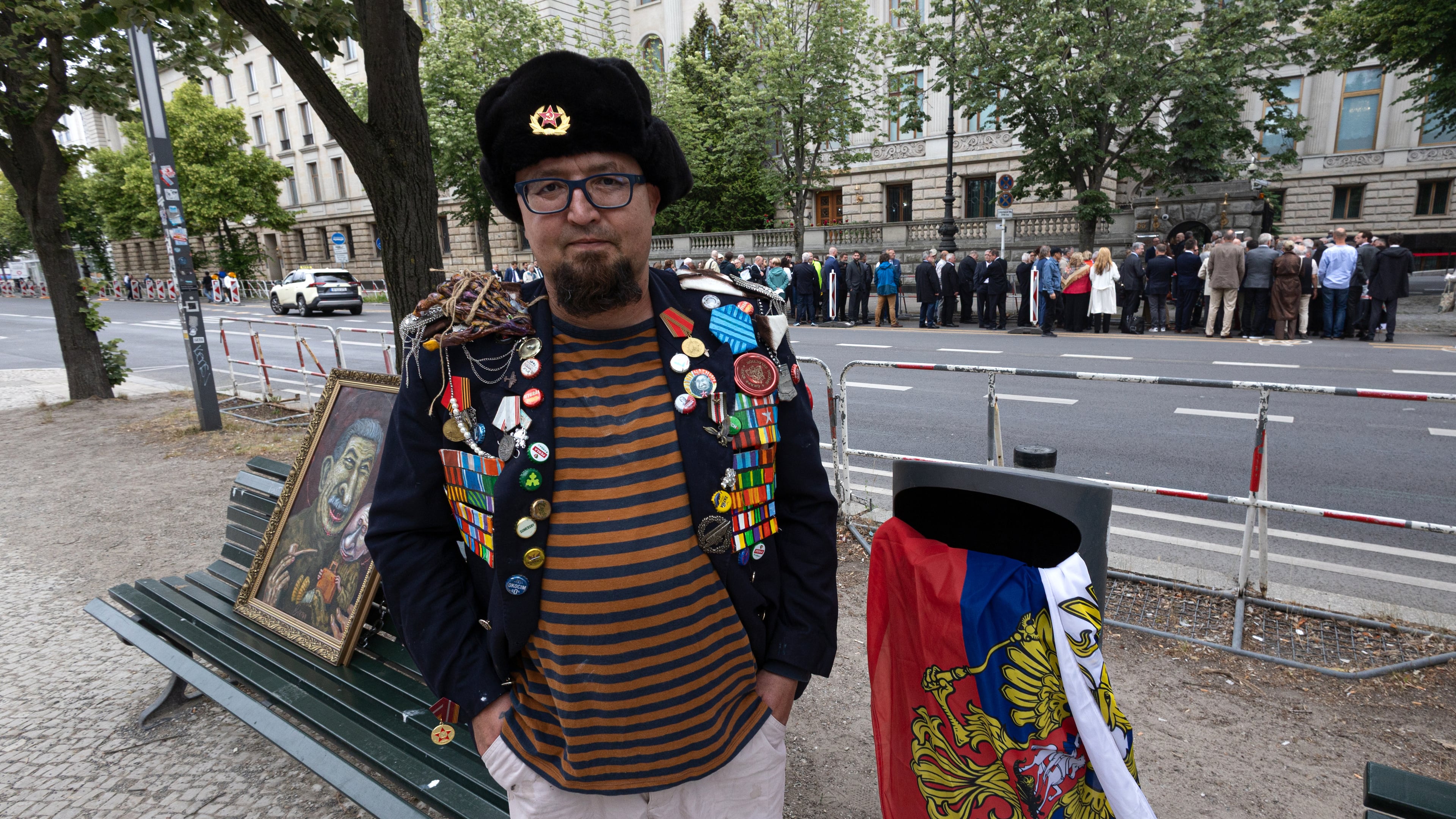 A man identified by Polish media as Robert Kuzovkov and by prosecutors as Robert K., in accordance with Polish privacy law, who they said was an artist who used the pseudonym Semyon Skrepetsky, poses for a photo with one of his paintings near the Russian Embassy in Berlin, Germany, on Friday, June 12, 2026, four days before Polish authorities said he was shot and killed in Biala Podlaska, Poland. (Vasily Krestyaninov/SOTA via AP)