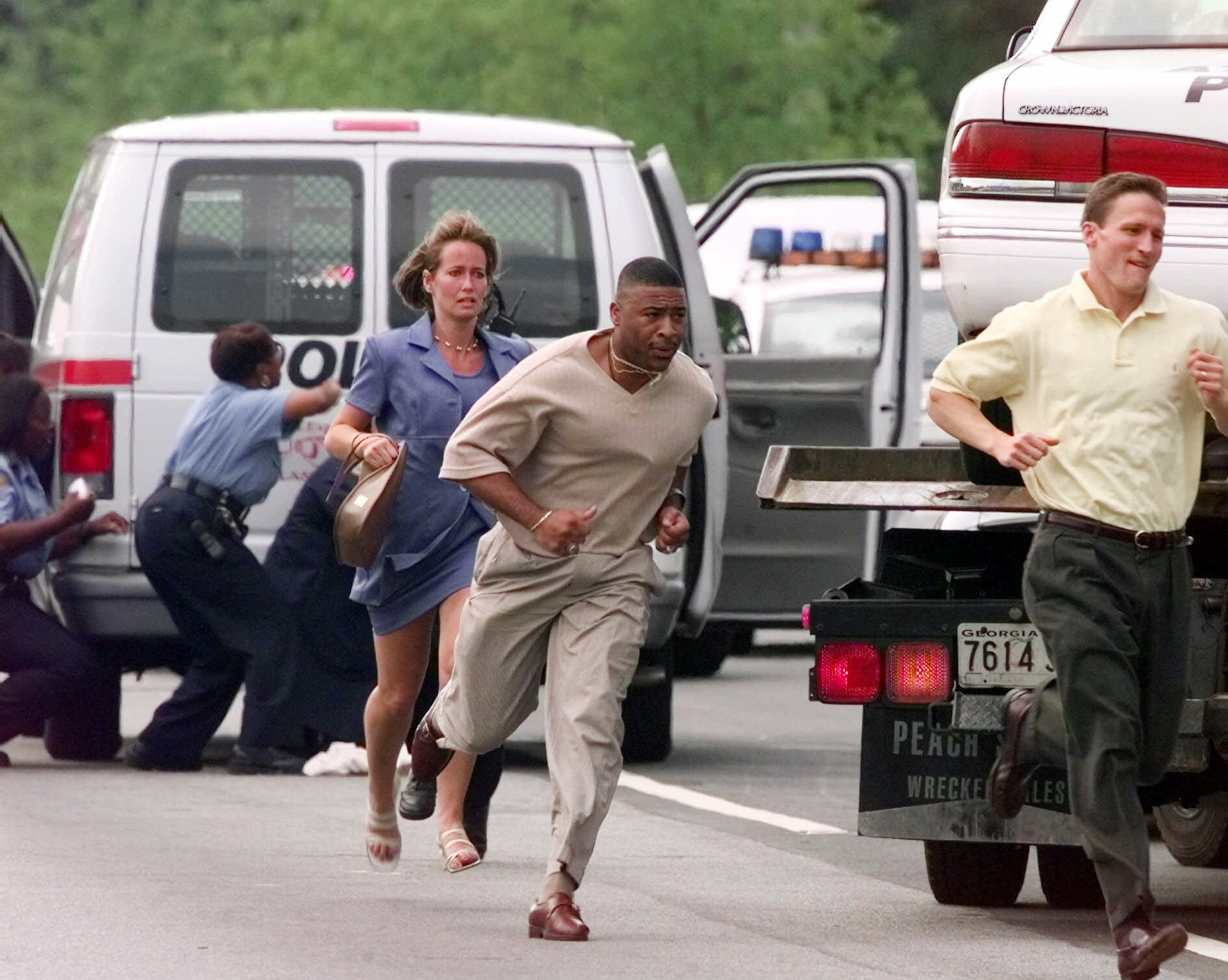 In July 1999, daytrader Mark Barton killed his wife and children before going on a shooting rampage first at his home and later at the Buckhead office complex where he worked, killing a total of nine people and wounding 13. Our photographers chronicled the day as it unfolded. Here, workers run from the scene of Barton's rampage at 3500 Piedmont Road. Official speculate that the motive for Barton's rampage stemmed from the fact that he had suffered $105,000 in losses over the previous two months daytrading. He started his rampage at his employer, Momentum Securities, and then continued his shooting spree at the nearby All Tech Investment Group.