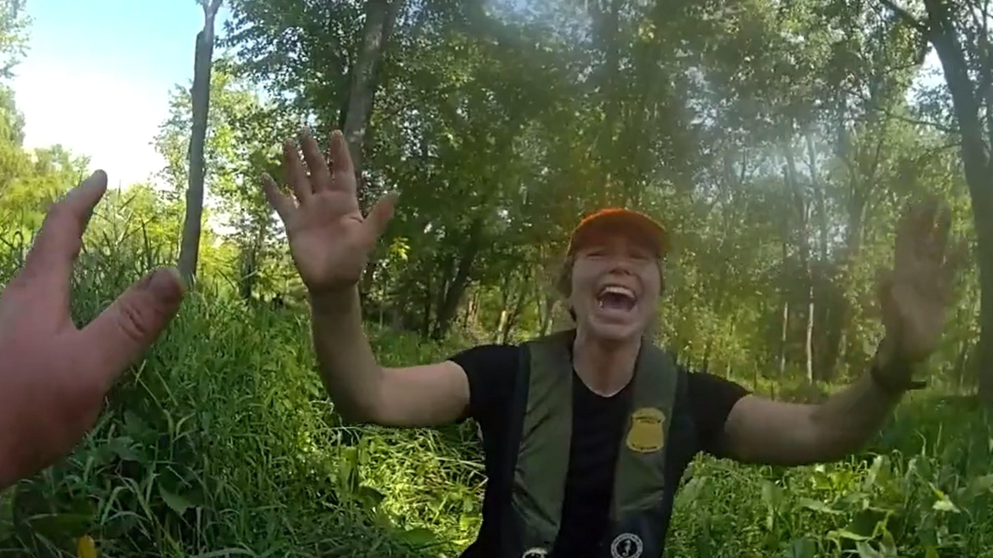 This image made from video provided by the Michigan Department of Natural Resources shows conservation officer Anna Cullen celebrating on Friday, Aug. 7, 2026, in Twin Lake, Mich., as a search and rescue team found two women and a child who had been missing after taking a river tubing trip. (