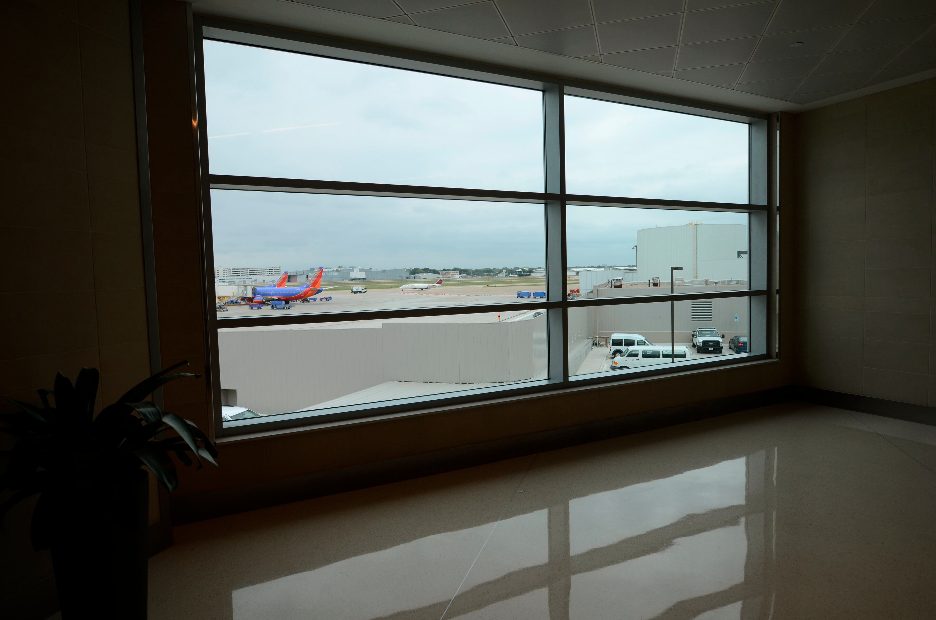 In this photo in 2013 in Dallas, a special viewing window that was custom built during the ongoing remodeling of the airport allows visitors to look out onto the area of the tarmac where Air Force One sat at Love Field on Nov. 22, 1963. (AP Photo/Benny Snyder)