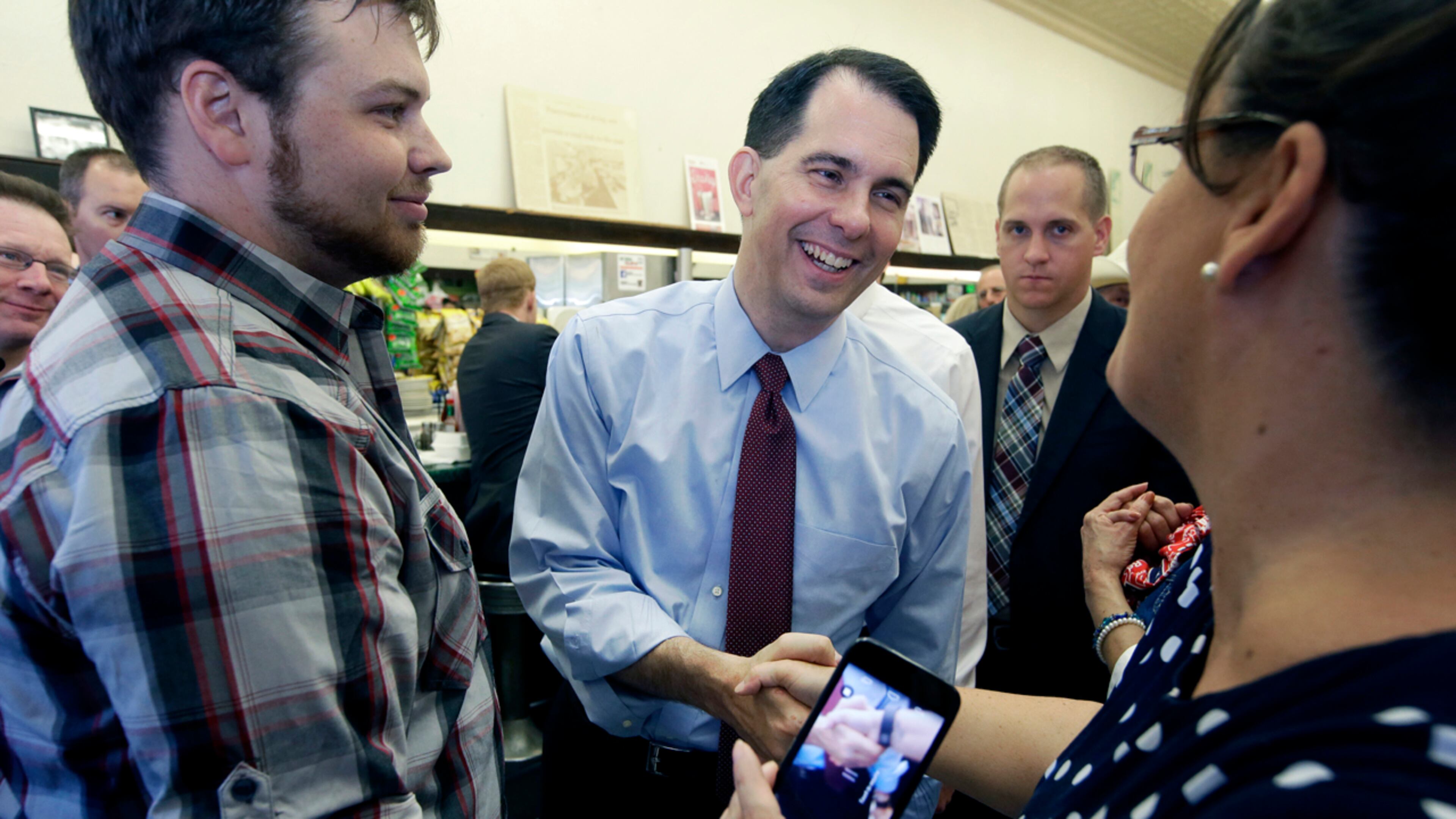 Republican presidential candidate Wisconsin Gov. Scott Walker, center, greets supporters Wednesday during a meet and greet visit to the Highland Park Soda Fountain in Dallas.