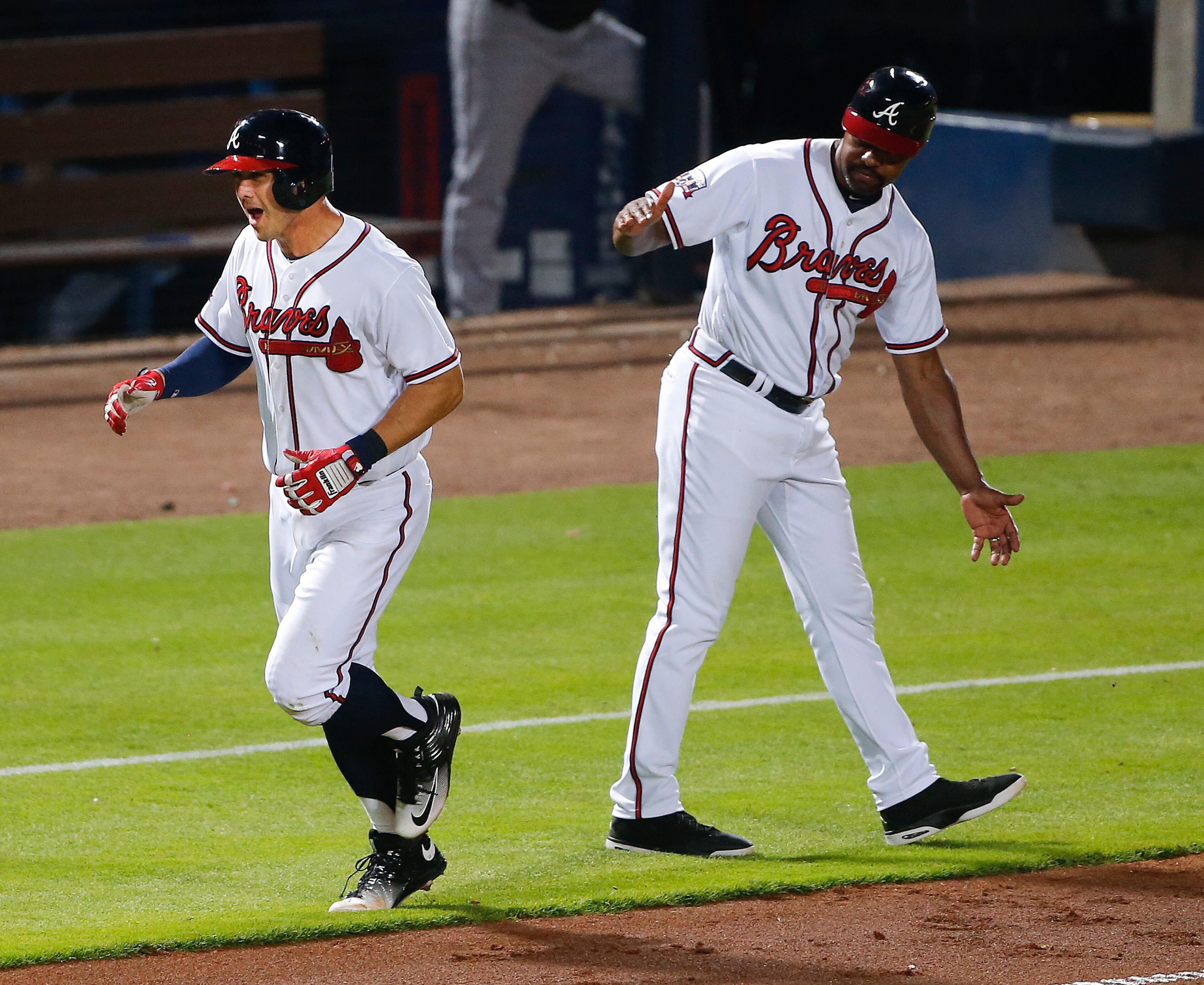 Atlanta Braves' Chase d'Arnaud, left, reacts as he passes third base coach Bo Porter after hitting a two-run home run in the fifth inning of a baseball game against the Miami Marlins, Friday, July 1, 2016, in Atlanta. (AP Photo/John Bazemore)