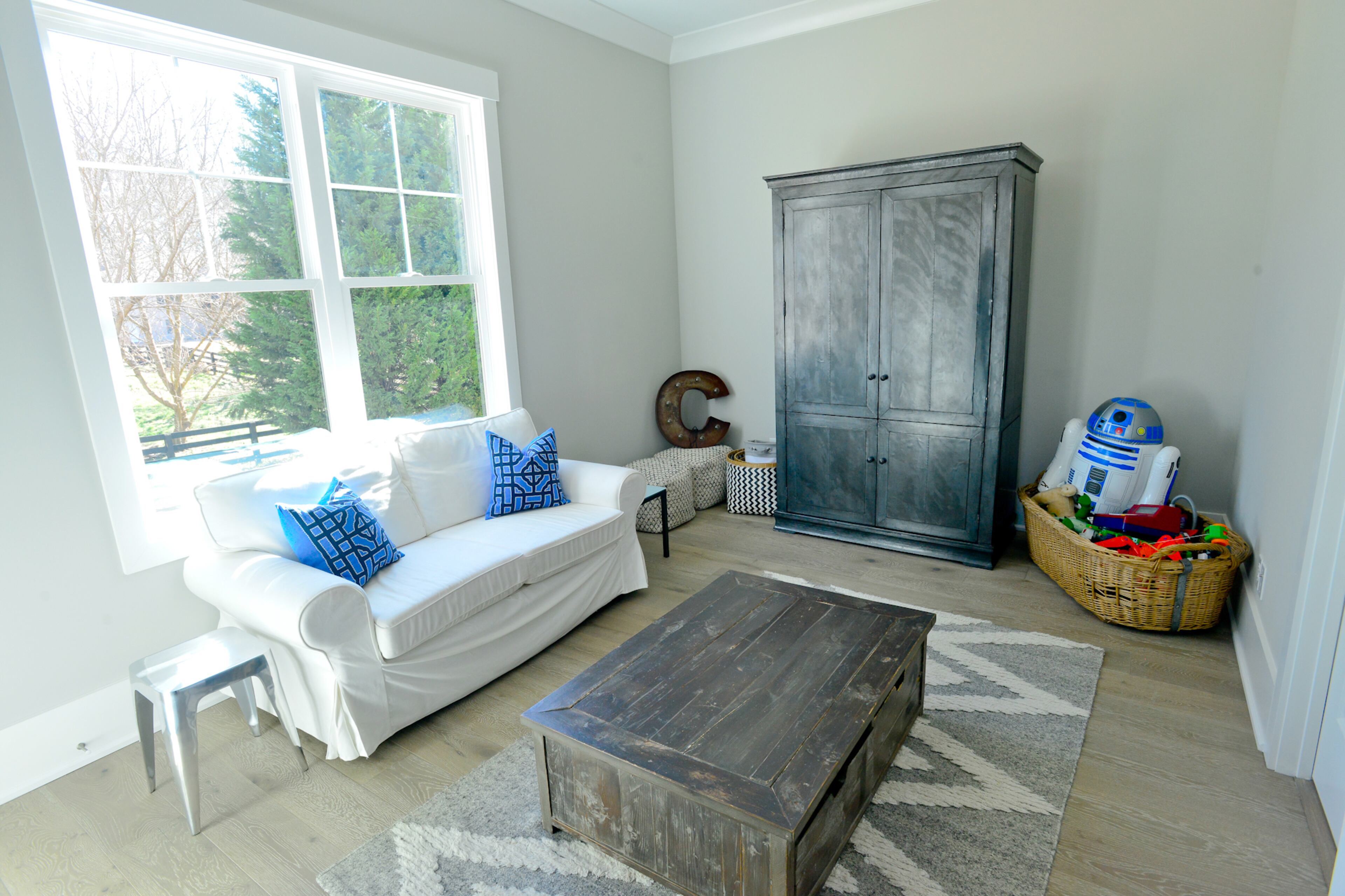 Homeowner Kristen Yonson's two young boys needed space to play indoors and store their toys. The Yonsons' five-bedroom Milton home features a playroom for Cole and Connor, outfitted with a zinc armoire RH Outlet, a play table from RH, an Ikea sofa and a West Elm rug.