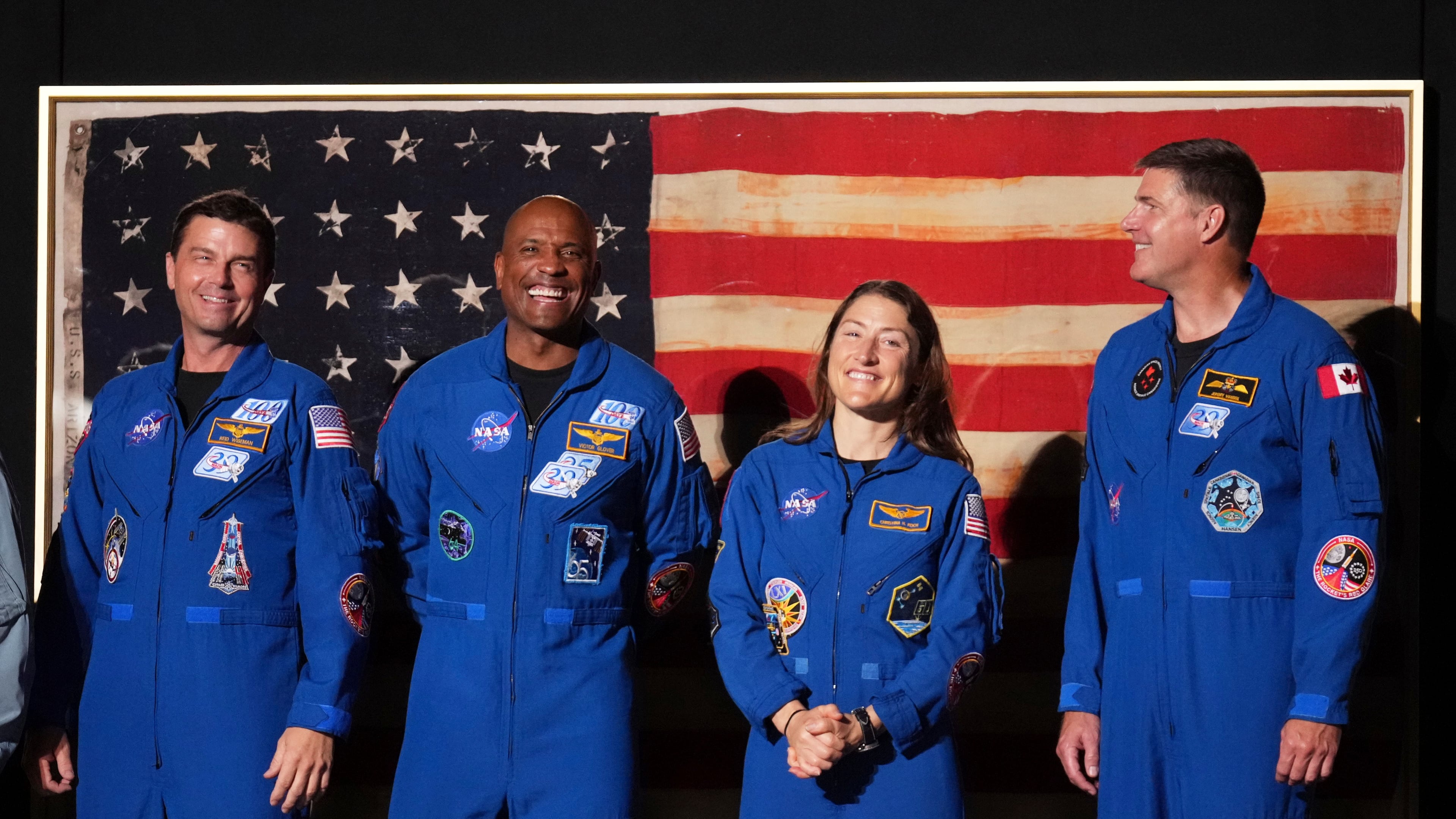 Artemis II crew members Reid Wiseman, from left, Victor Glover, Christina Koch and Jeremy Hansen stand as President Donald Trump speaks during Salute to America, an Independence Day event honoring the nation's 250th anniversary, Saturday, July 4, 2026, on the National Mall in Washington. (AP Photo/Mark Schiefelbein)