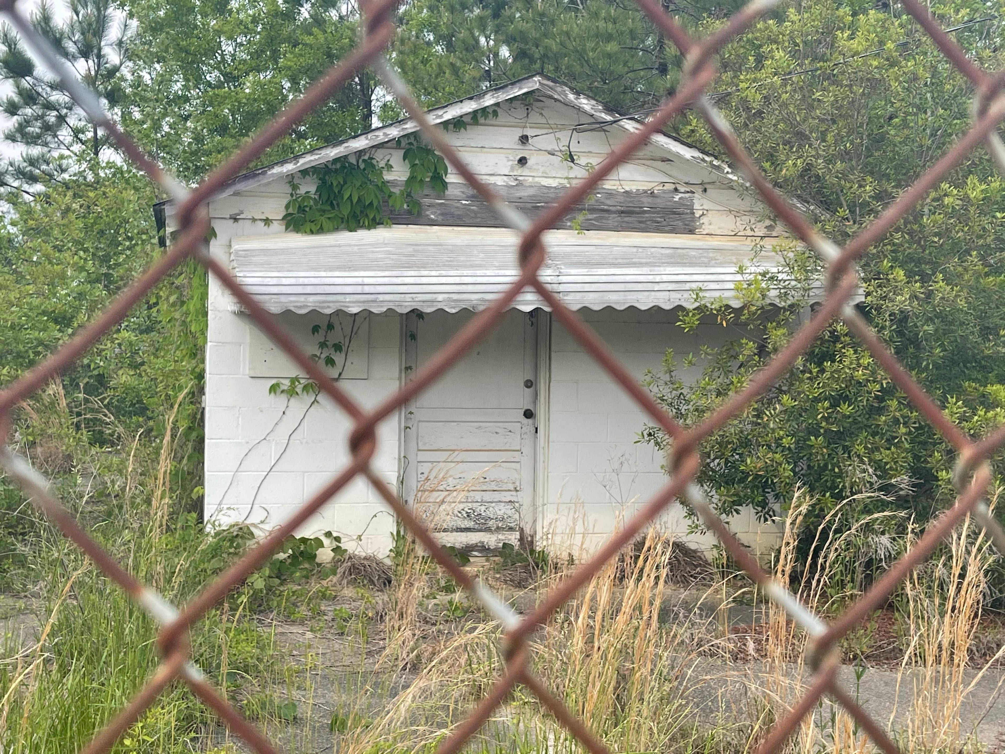 The city's former city hall building, on a dusty side street called City Hall Road, is being reclaimed by nature. (Tyler Wilkins / tyler.wilkins@ajc.com)