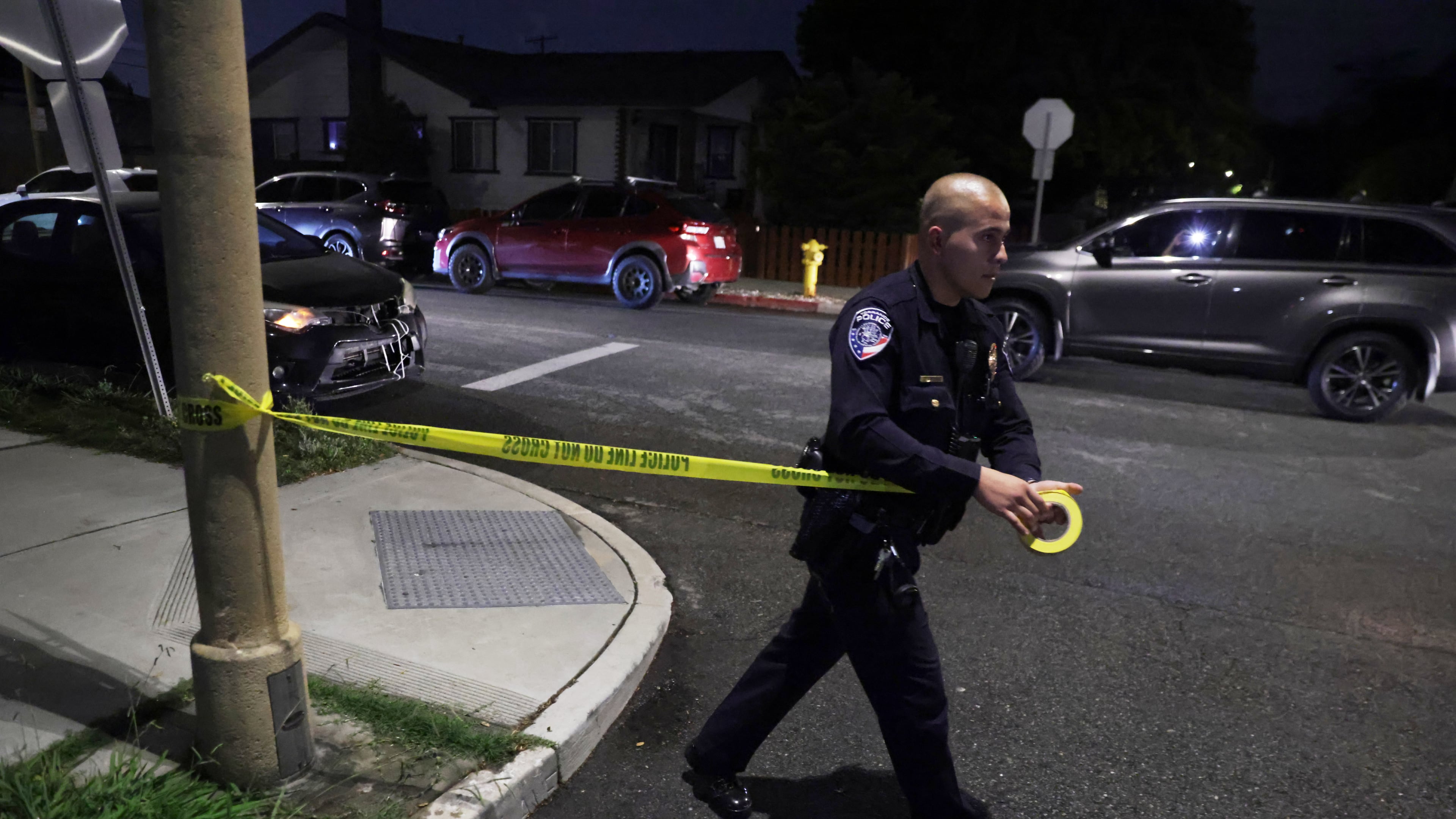A law enforcement officer sets up police tape near an address connected to Cole Tomas Allen, the shooting suspect at the White House Correspondents Dinner on Saturday, April 25, 2026, in Torrance, Calif. (AP Photo/Ethan Swope)