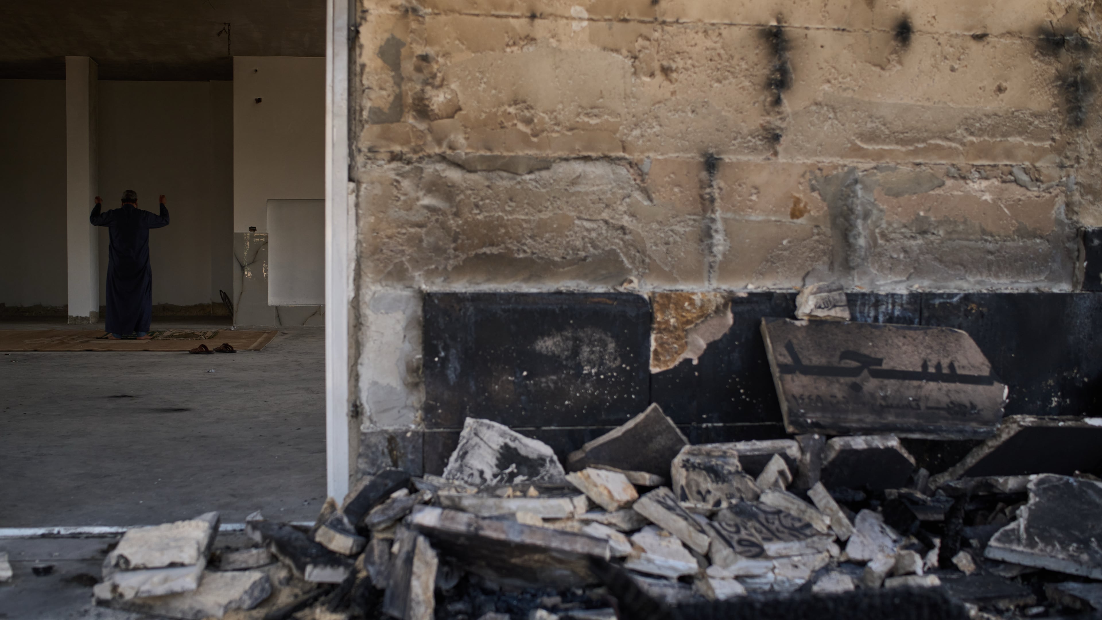 A Palestinian man prays inside a mosque that was burned during an attack by Israeli settlers early in the morning in the West Bank village of Qusra, Sunday, July 26, 2026. (AP Photo/Leo Correa)