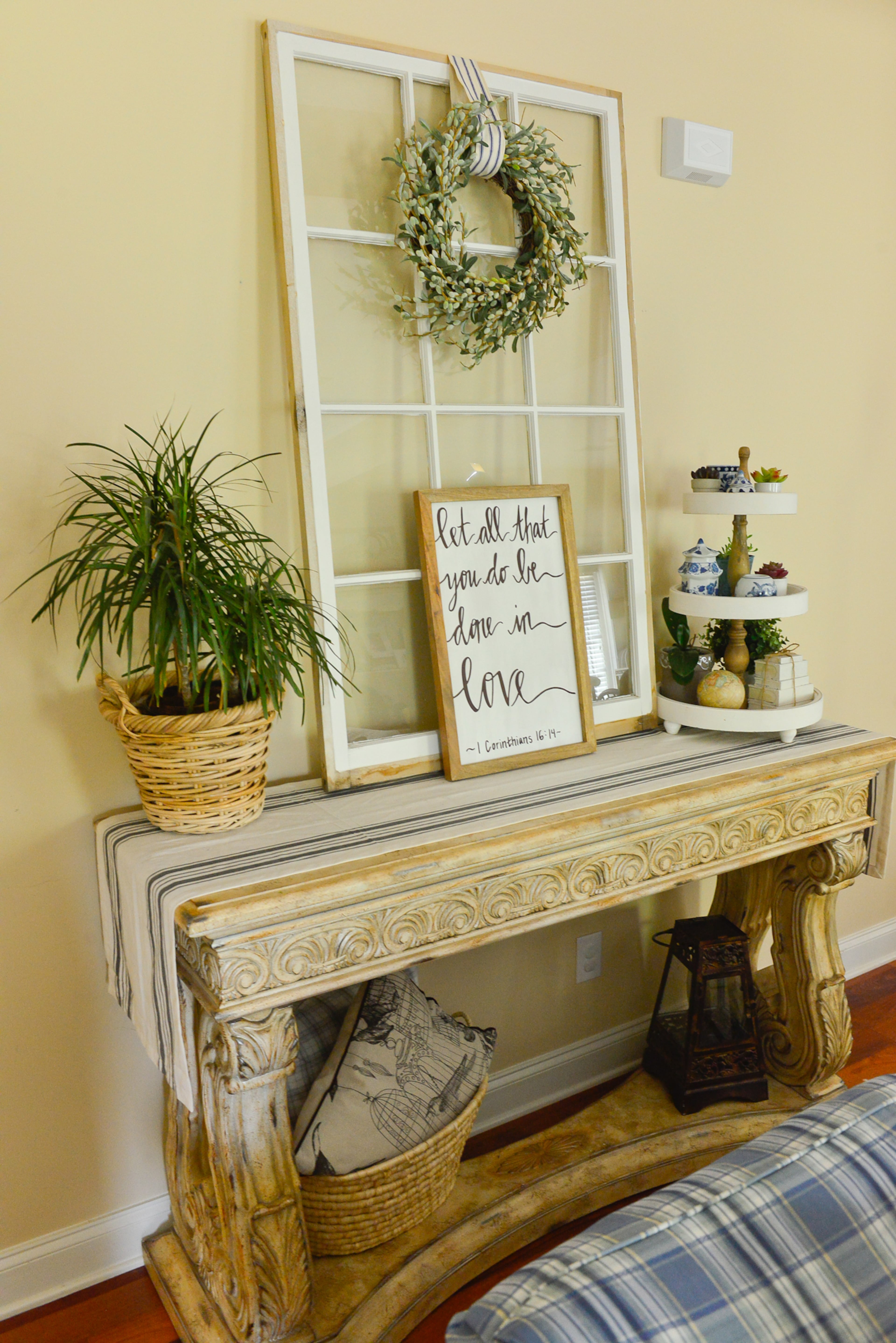 Decor: The large stone console was also a family heirloom, and the window pane atop it is an antique find from Lakewood 400 Antiques Market in Cumming. Homeowner Yuni Min uses baskets and textiles like the ones on the bottom tier of this table to keep her home warm and inviting.