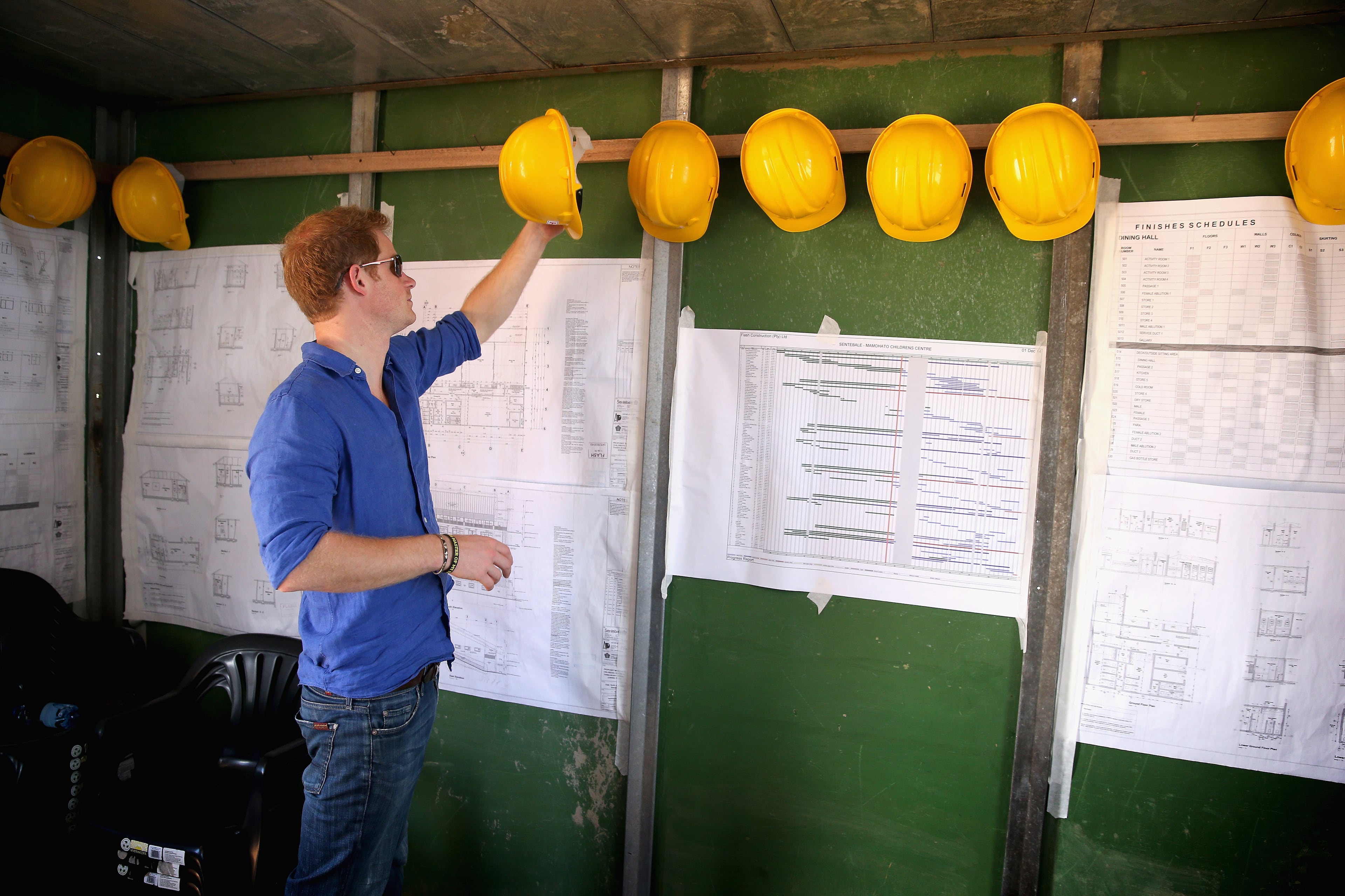 Prince Harry picks a hard hat as he helps at the construction site for the new Sentebale Mamohato Children's Centre at Thaba-Bosiu on December 10, 2014 in Maseru, Lesotho. Prince Harry was visiting Lesotho to see the work of his charity Sentebale. Sentebale provides healthcare and education to vulnerable children in Lesotho, Southern Africa. The particular theme of his visit was to check on the progress of the Mamohato Childrens Centre which will provide vital support to children affected by HIV. Prince Harry founded Sentebale (which means Forget Me Not in Sesotho) with Prince Seeiso in 2006. (Photo by Chris Jackson/Getty Images for Sentebale)