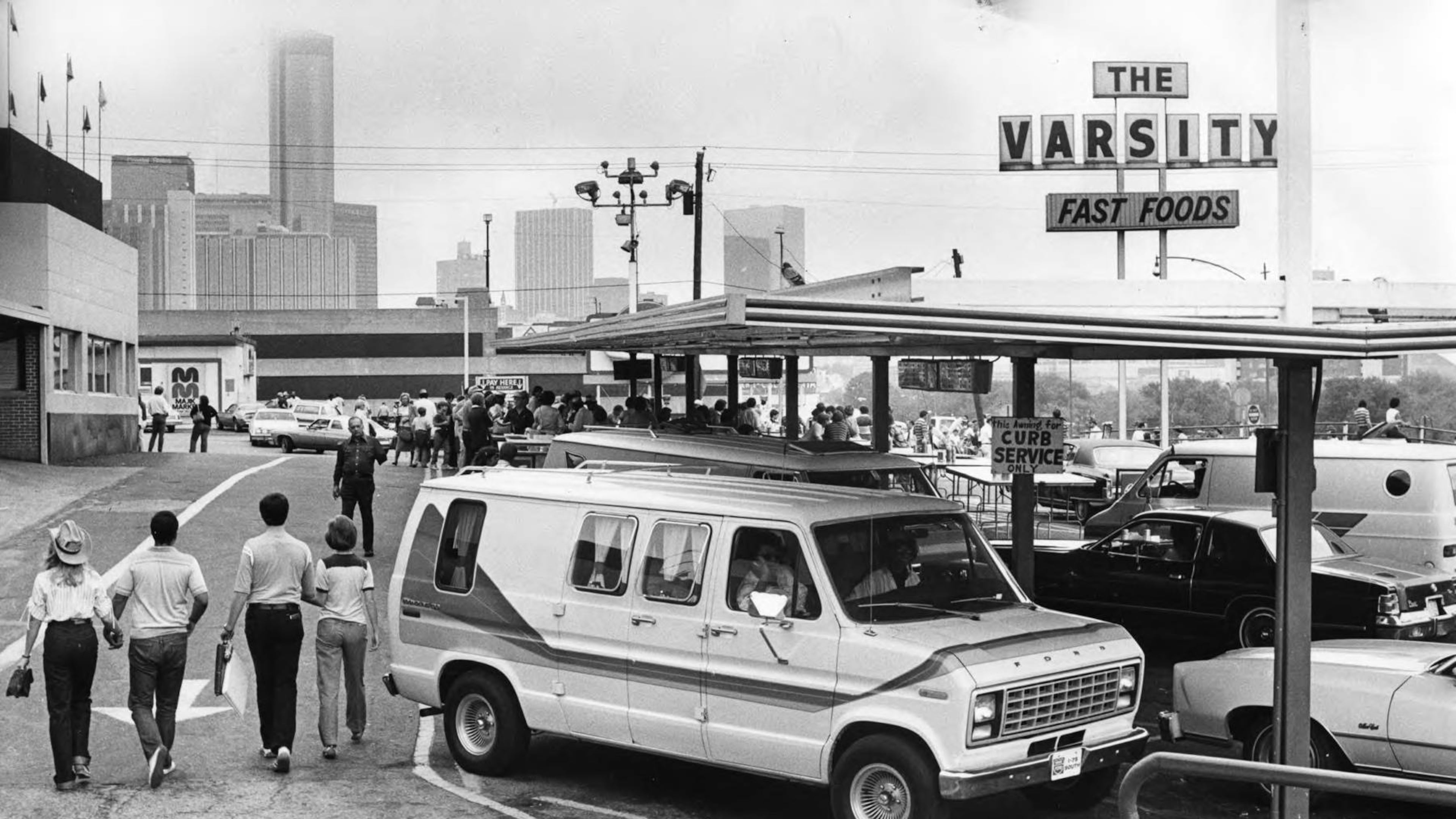 Cars parked outside of the Varsity Drive-In restaurant, with the downtown skyline in the background in 1985. (AJC file)