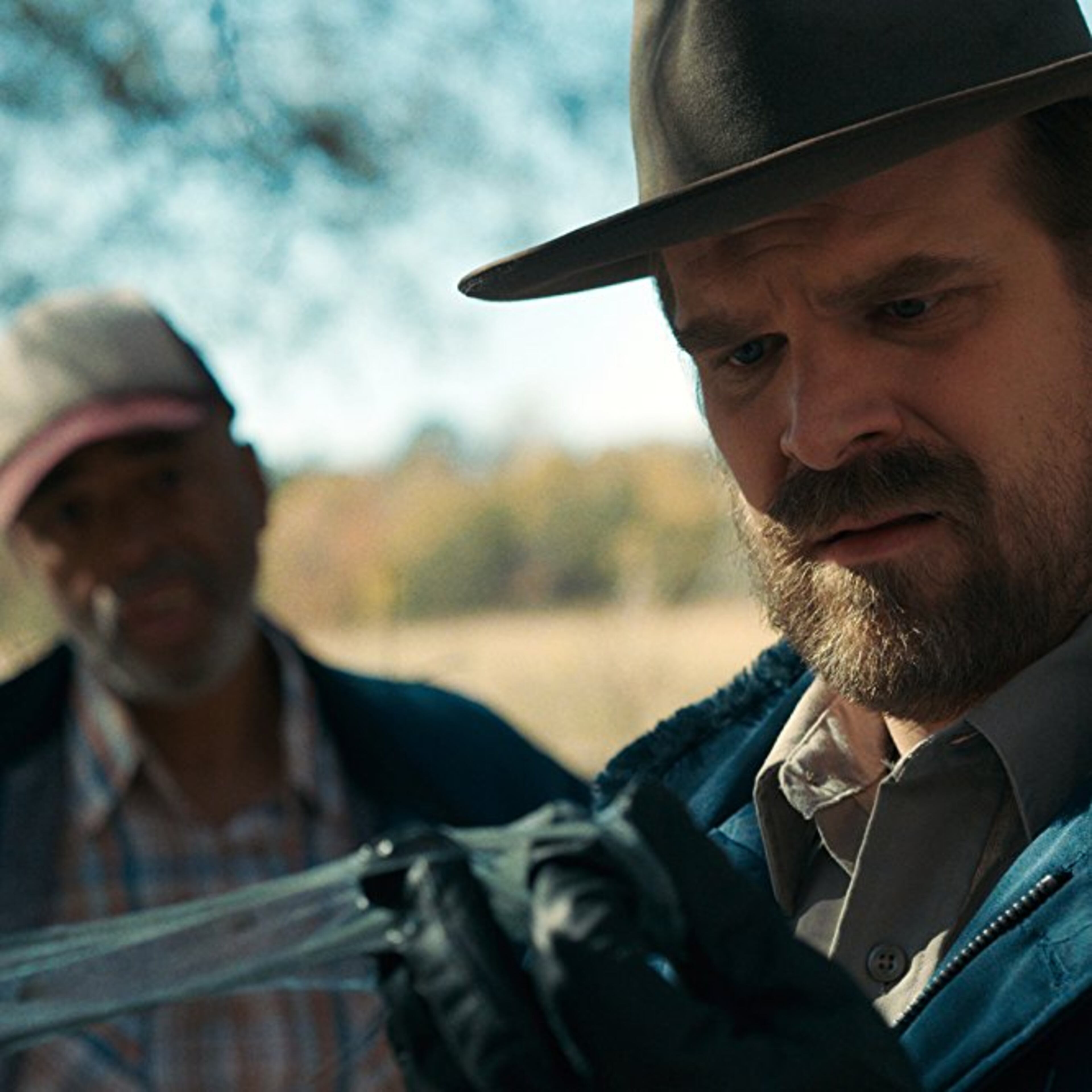 Al Mitchell in the blurry background behind David Harbour as a farmer.
