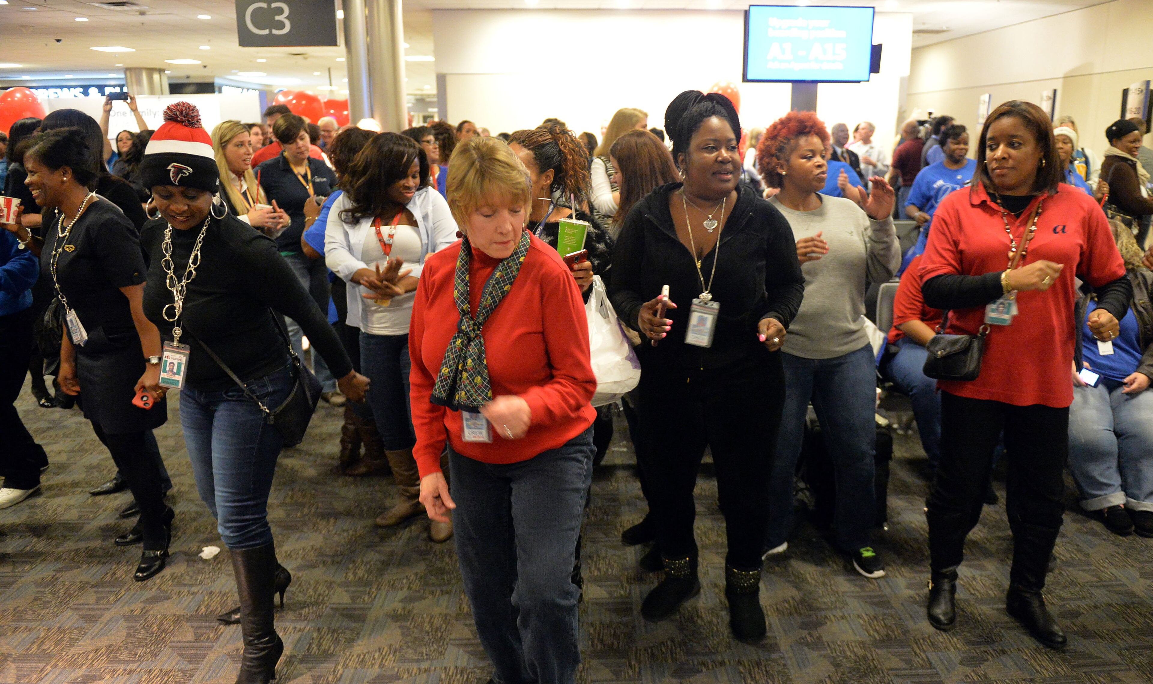Employees dance during the celebration. Hundreds of Southwest Airlines and former AirTran Airways employees gathered at Concourse C, gates 1, 2 and 3 to celebrate the departure of AirTran’s final flight to Tampa, at Hartsfield-Jackson International Airport, Sunday, December 28, 2014. Southwest CEO Gary Kelly and executives Bob Jordan and Jack Smith gave remarks during the program. The full flight was waved off by employees that gathered on the tarmac as crash trucks from Atlanta Fire Rescue gave a final water cannon salute as the plane departed. KENT D. JOHNSON/KDJOHNSON@AJC.COM