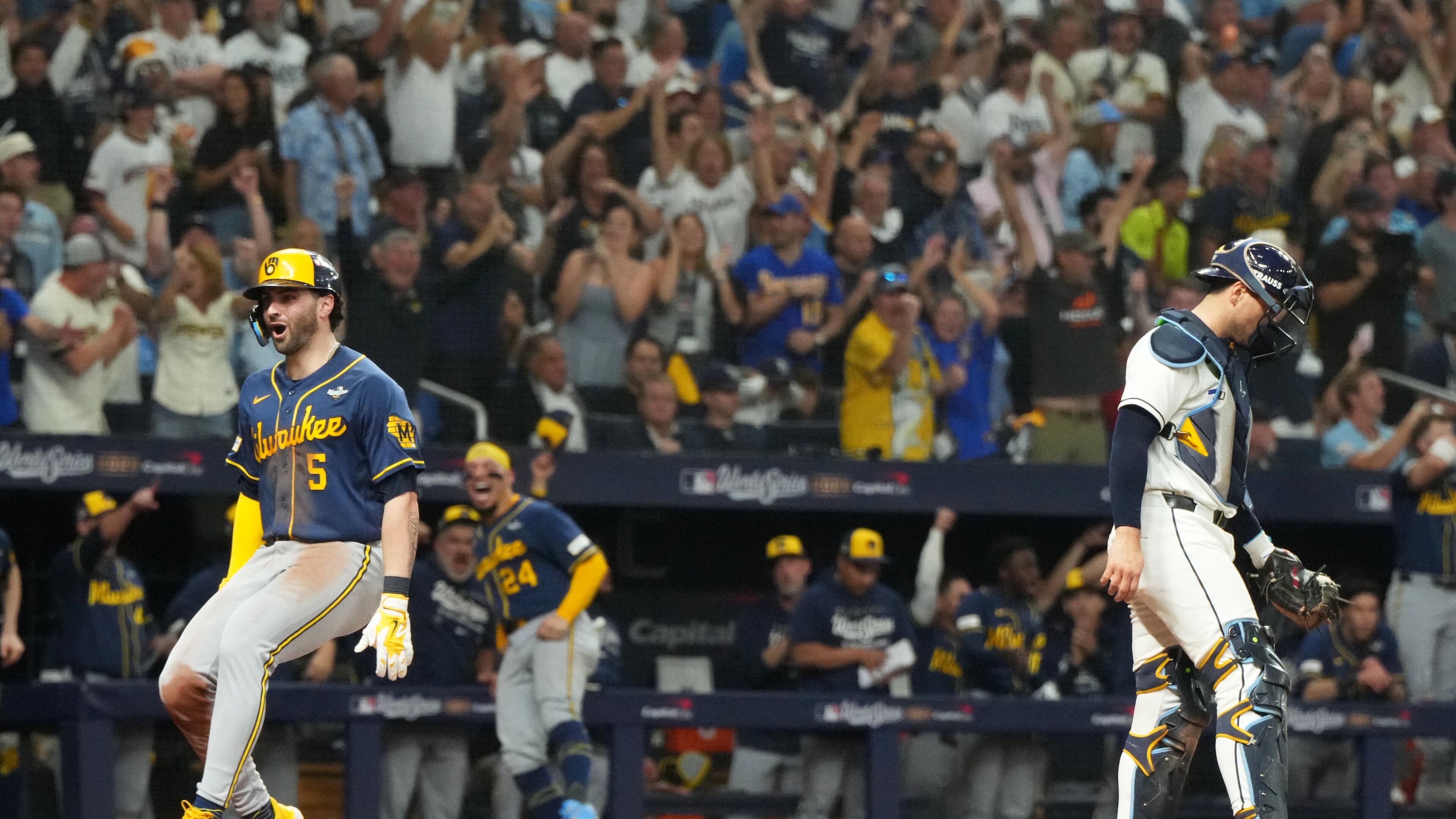 Milwaukee Brewers' Garrett Mitchell celebrates past Tampa Bay Rays catcher Nick Fortes after scoring during the fifth inning of Game 3 of baseball's World Series, Monday, Oct. 26, 2026, in St. Petersburg, Fla., between the Milwaukee Brewers and the Tampa Bay Rays. (AP Photo/Ashley Landis)