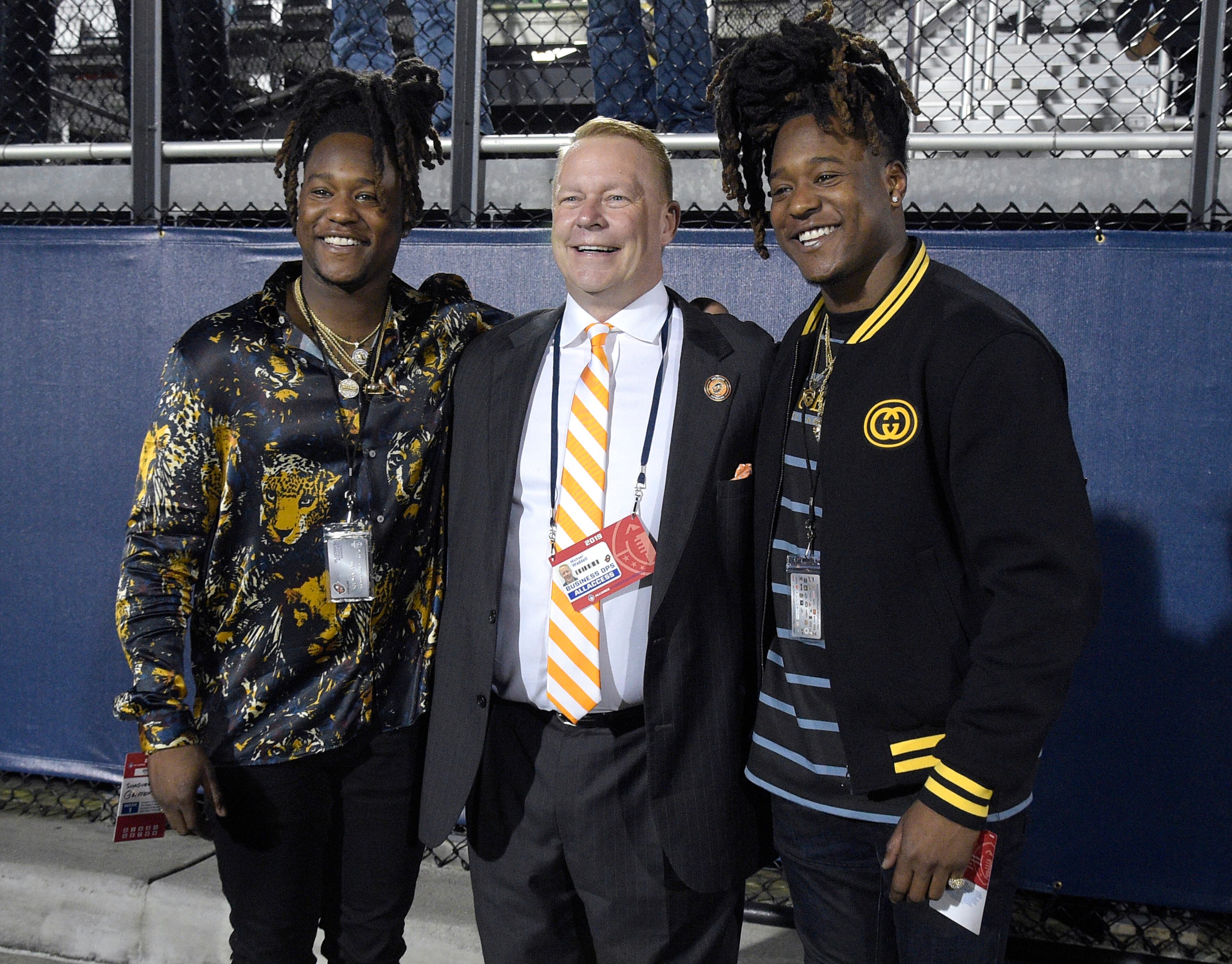 Orlando Apollos president Michael Waddell, center, poses on the sideline with Seattle Seahawks linebacker Shaquem Griffin, left, and defensive back Shaquill Griffin during the first half of the team's Alliance of American Football game against the Atlanta Legends on Saturday, Feb. 9, 2019, in Orlando, Fla. (AP Photo/Phelan M. Ebenhack)