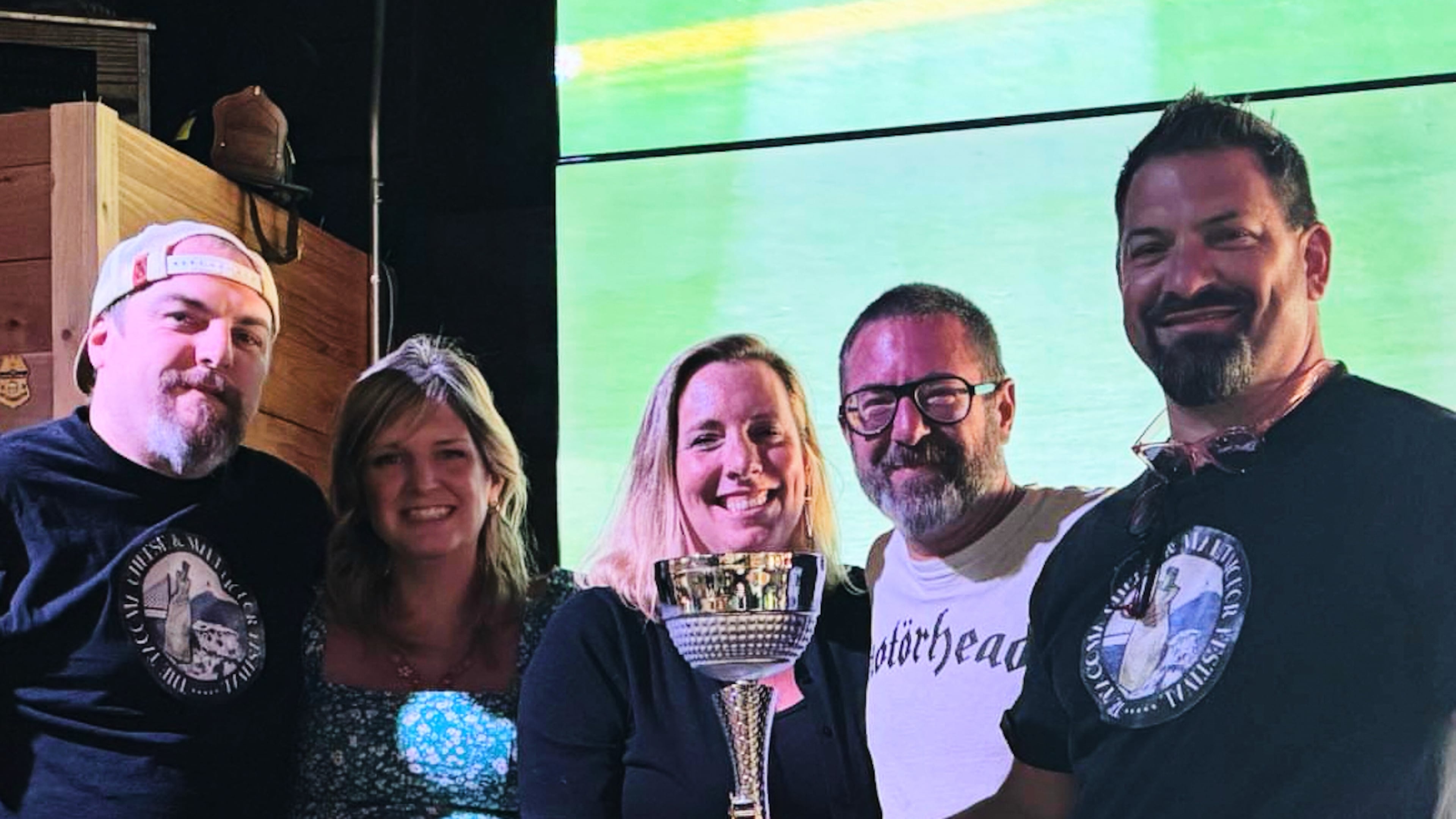 This photo provided by Kole Musgrove shows John Forsberg, far right, holding a trivia championship trophy and poses for a photo with other members of his team at Ashtown Brewing Company in Longview, Wash, on July 1, 2025. (Kole Musgrove via AP)