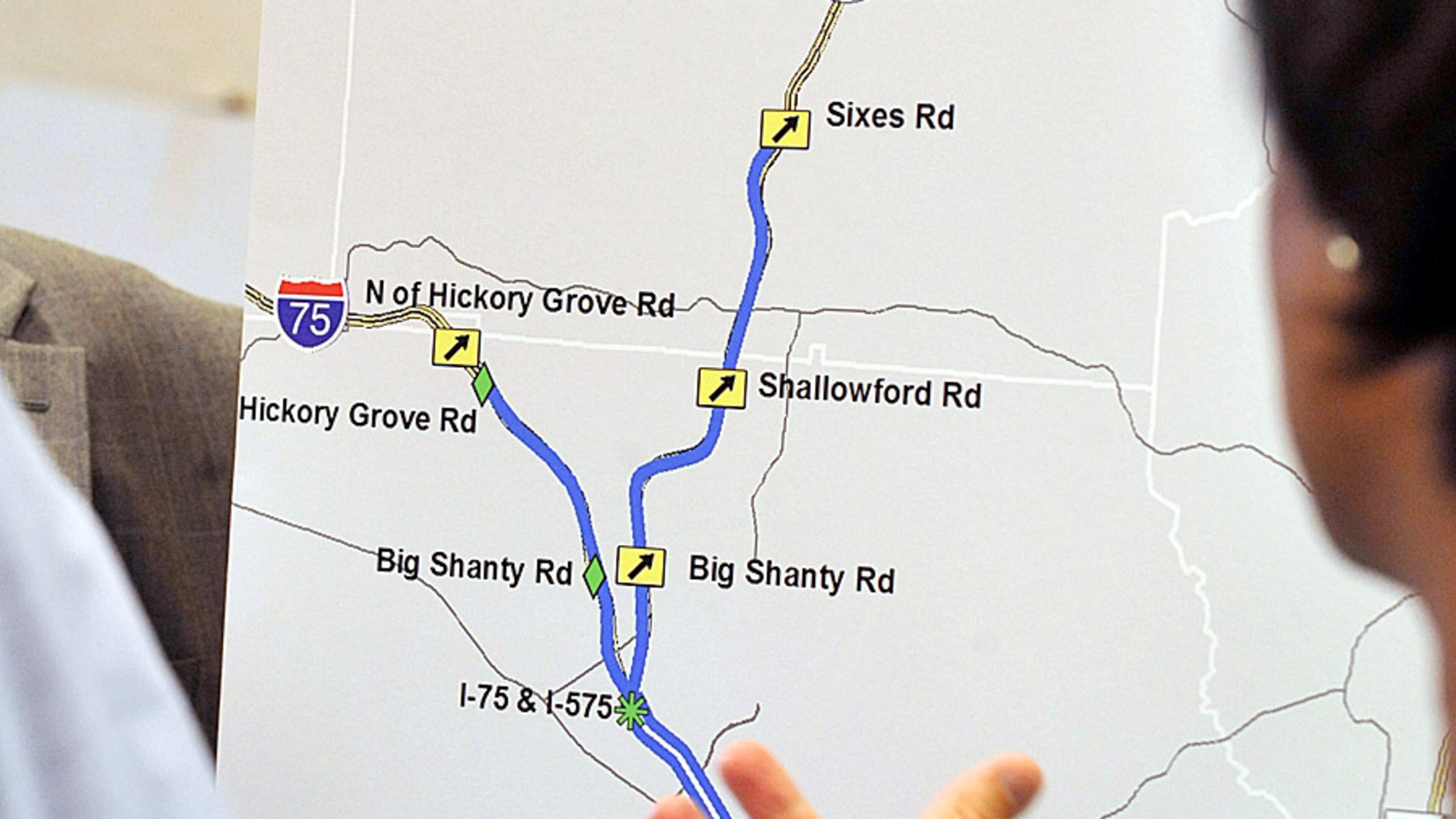 A map showing the route and interchanges of the I-75/I-575 Northwest Corridor project in Cobb and Cherokee counties. Above the I-575 interchange, one new reversible lane will be added in the I-75 center median to Hickory Grove Road and a similar new I-575 lane will extend to Sixes Road. Drivers will have to pay a variable-rate toll, based on traffic volume, for access to the lanes.