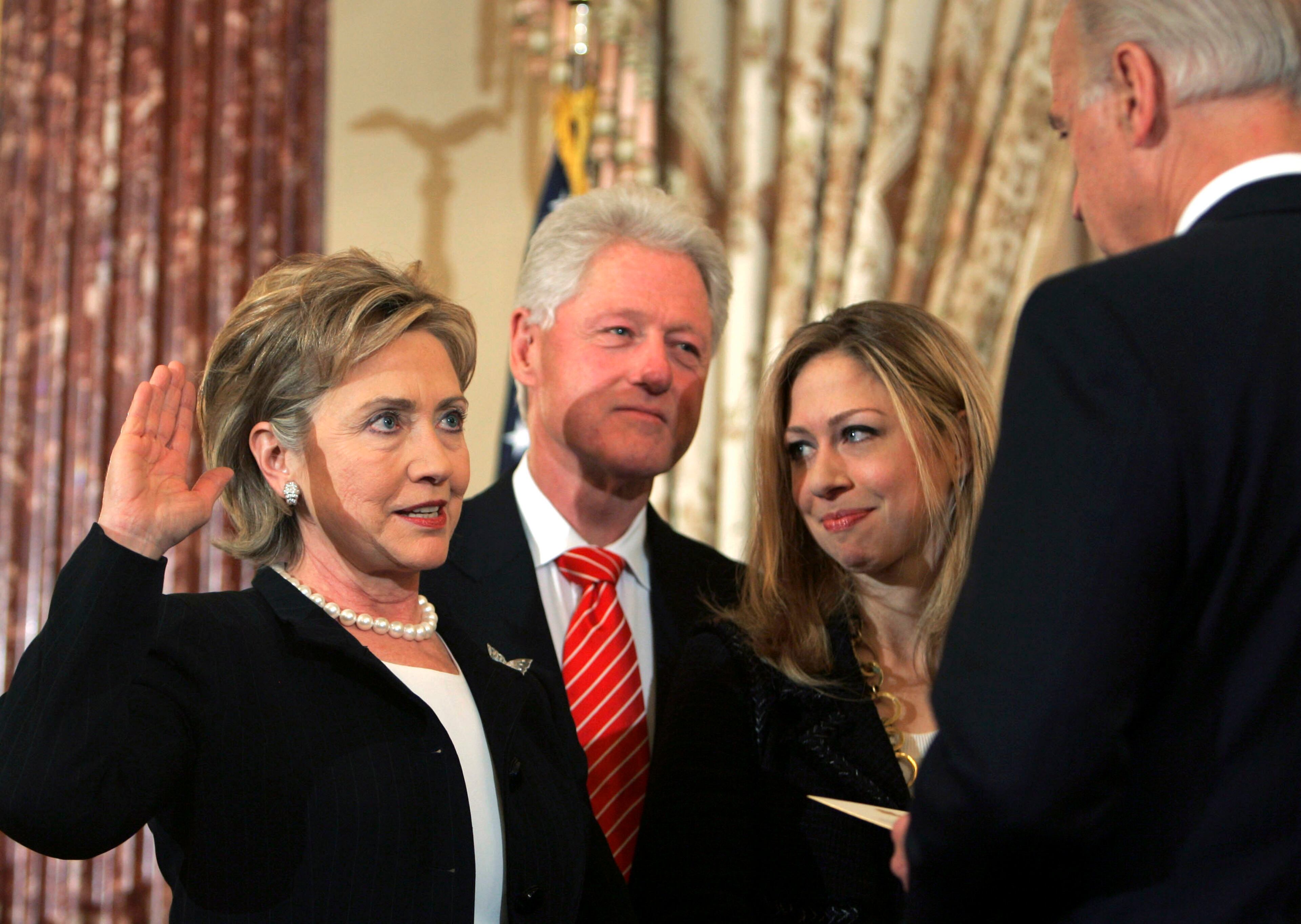 In this Monday, Feb. 2, 2009 file photo, Vice President Joe Biden, right, swears in Secretary of State Hillary Clinton in a ceremonial swearing-in at the State Department in Washington, accompanied by her husband, former President Bill Clinton, and their daughter, Chelsea. (AP Photo/Lawrence Jackson)