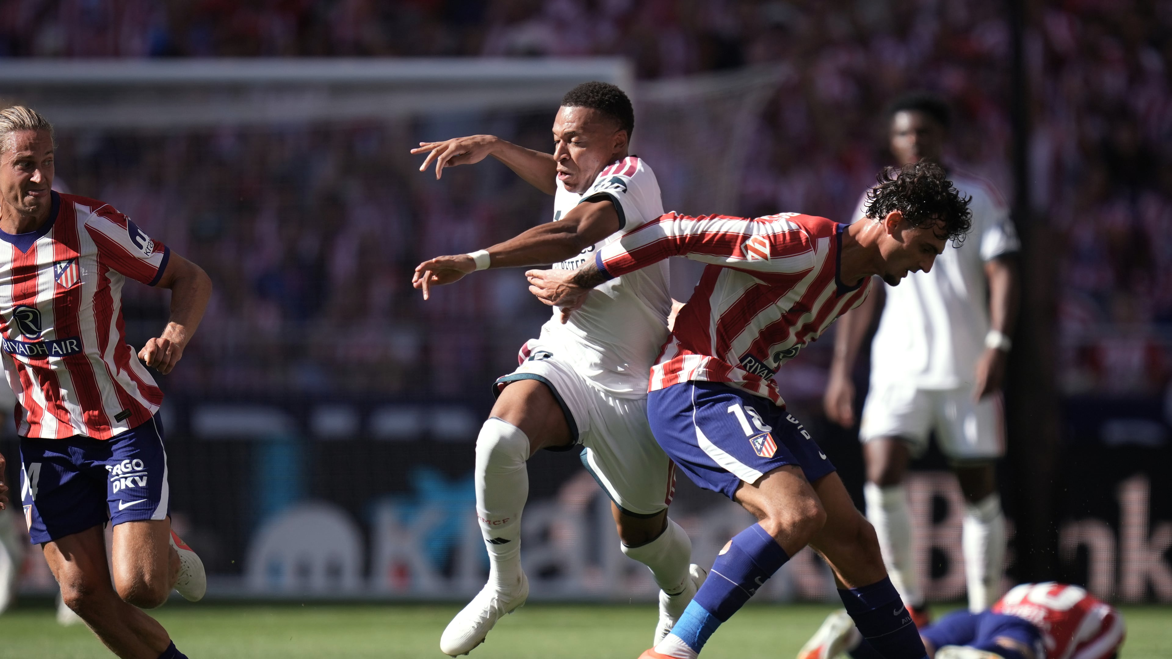Real Madrid's Kylian Mbappe tries to get past Atletico Madrid's Marc Pubill, right, and Marcos Llorente during a Spanish La Liga soccer match between Atletico Madrid and Real Madrid in Madrid, Sunday, Sept. 20, 2026. (AP Photo/Bernat Armangue)