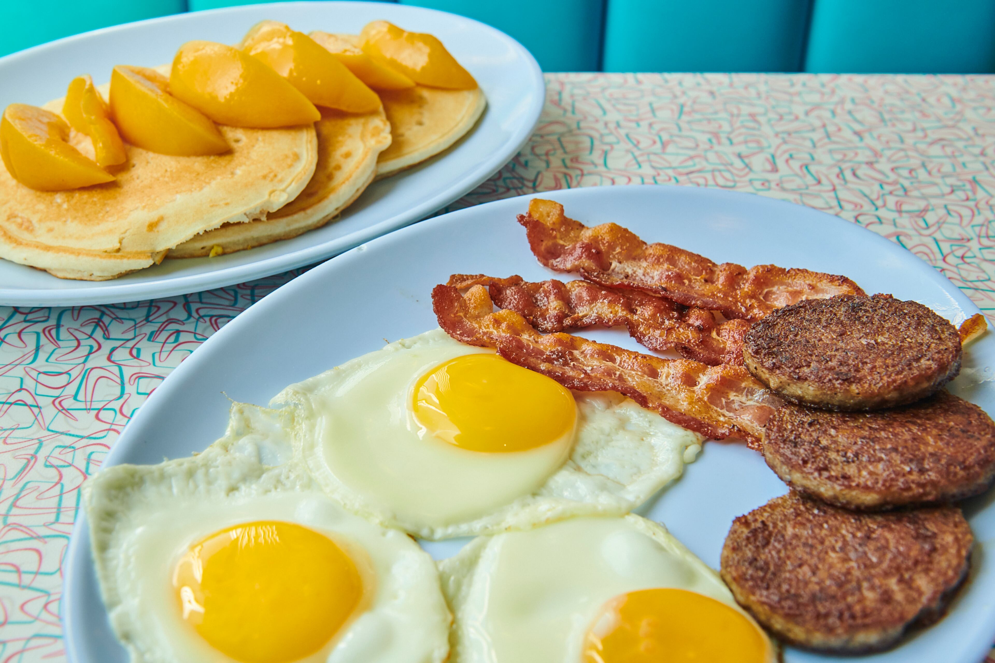 The Triple Crown breakfast plate at Savannah's Palace Diner comes with three strips of bacon, three sausage patties, three eggs and three pancakes (shown with peach slices). (Greg Rannells for The Atlanta Journal-Constitution)
