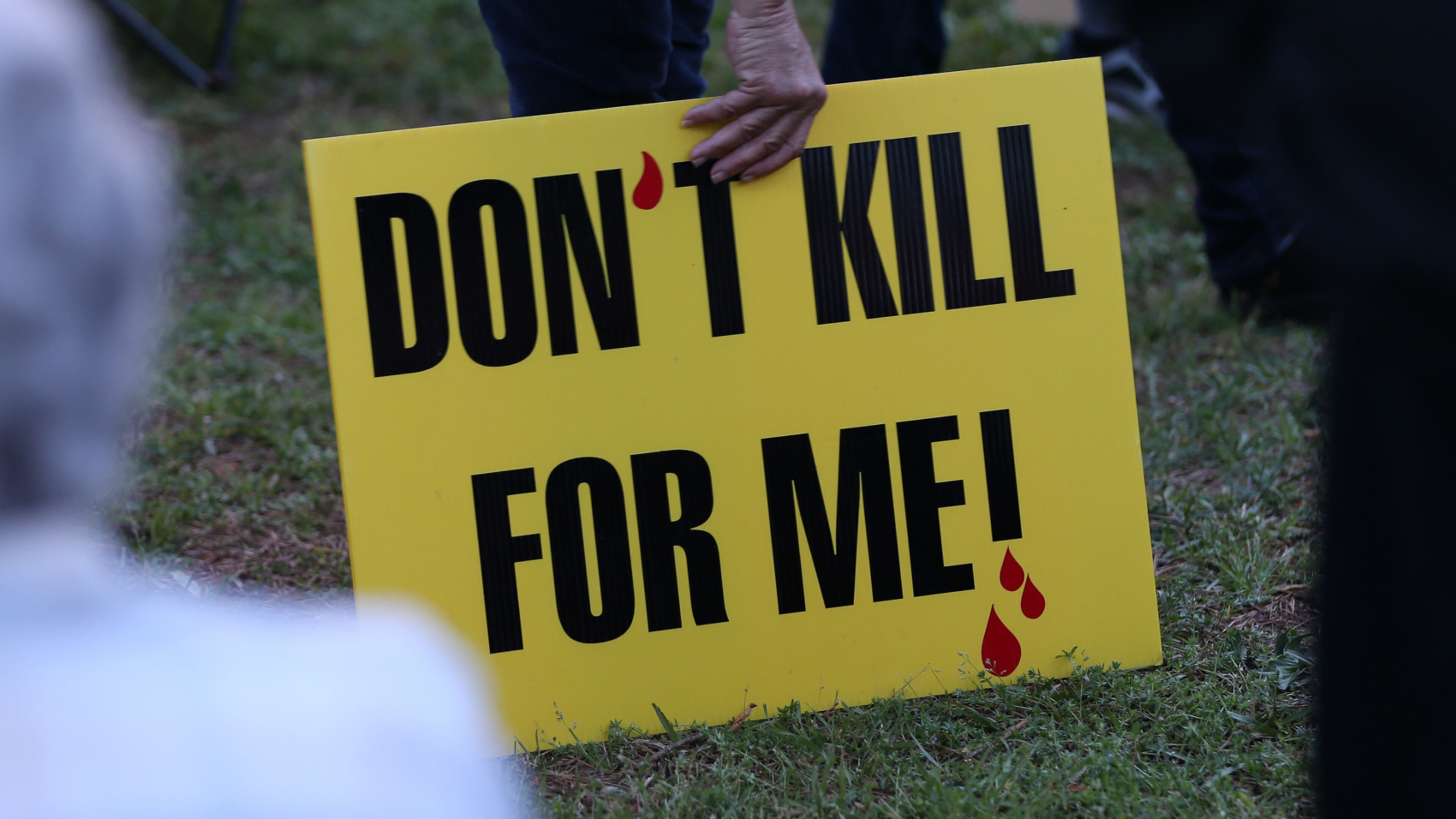 GENERIC CUTLINE: A death penalty opponent holds a sign outside the Georgia Diagnostic and Classification State Prison in Butts County during a protest in March 2016. The state's execution chamber is located at the prison. (credit: Ben Gray/ AJC 2016 file photo)ORIGINAL CUTLINE: March 31, 2016 Jackson: A death penalty opponent picks up her sign while protesting outside of the Georgia Diagnostic and Classification State Prison in advance of the scheduled execution of Joshua Bishop on Thursday evening March 31, 2016. Ben Gray / bgray@ajc.com