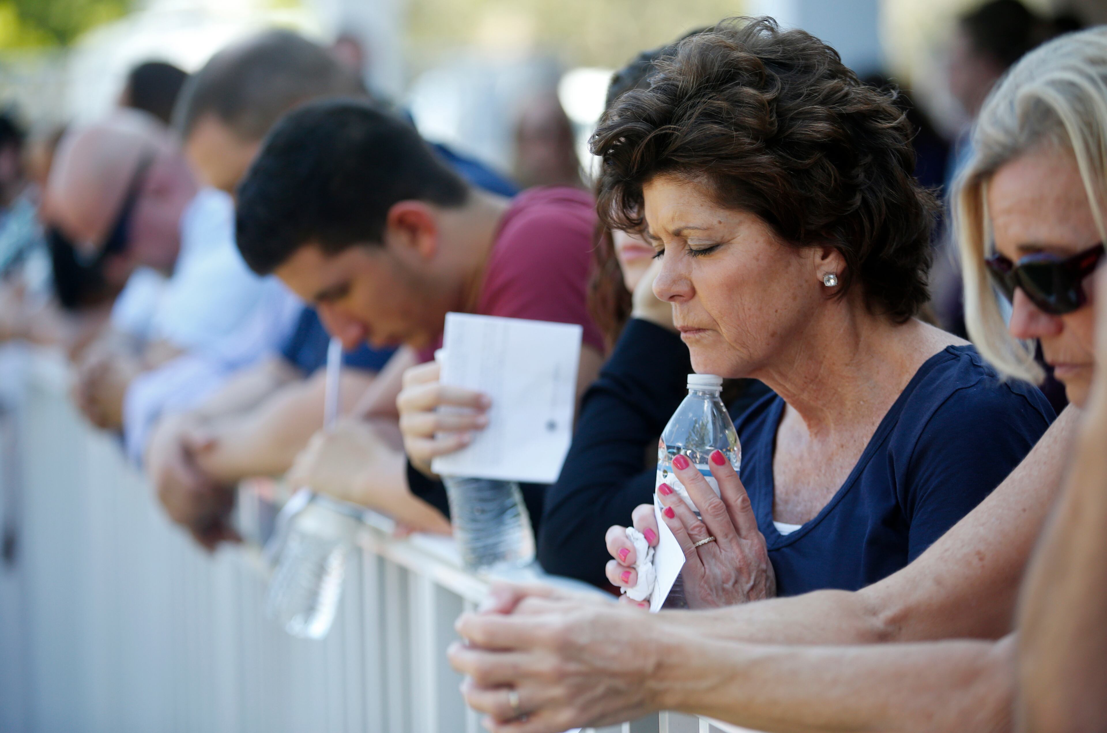 Attendees pray together at a vigil for the victims of the shooting at Marjory Stoneman Douglas High School at the Parkland Baptist Church, Thursday, Feb. 15, 2018 in Parkland, Fla. Nikolas Cruz, a former student, was charged with 17 counts of premeditated murder Thursday morning. (AP Photo/Wilfredo Lee)
