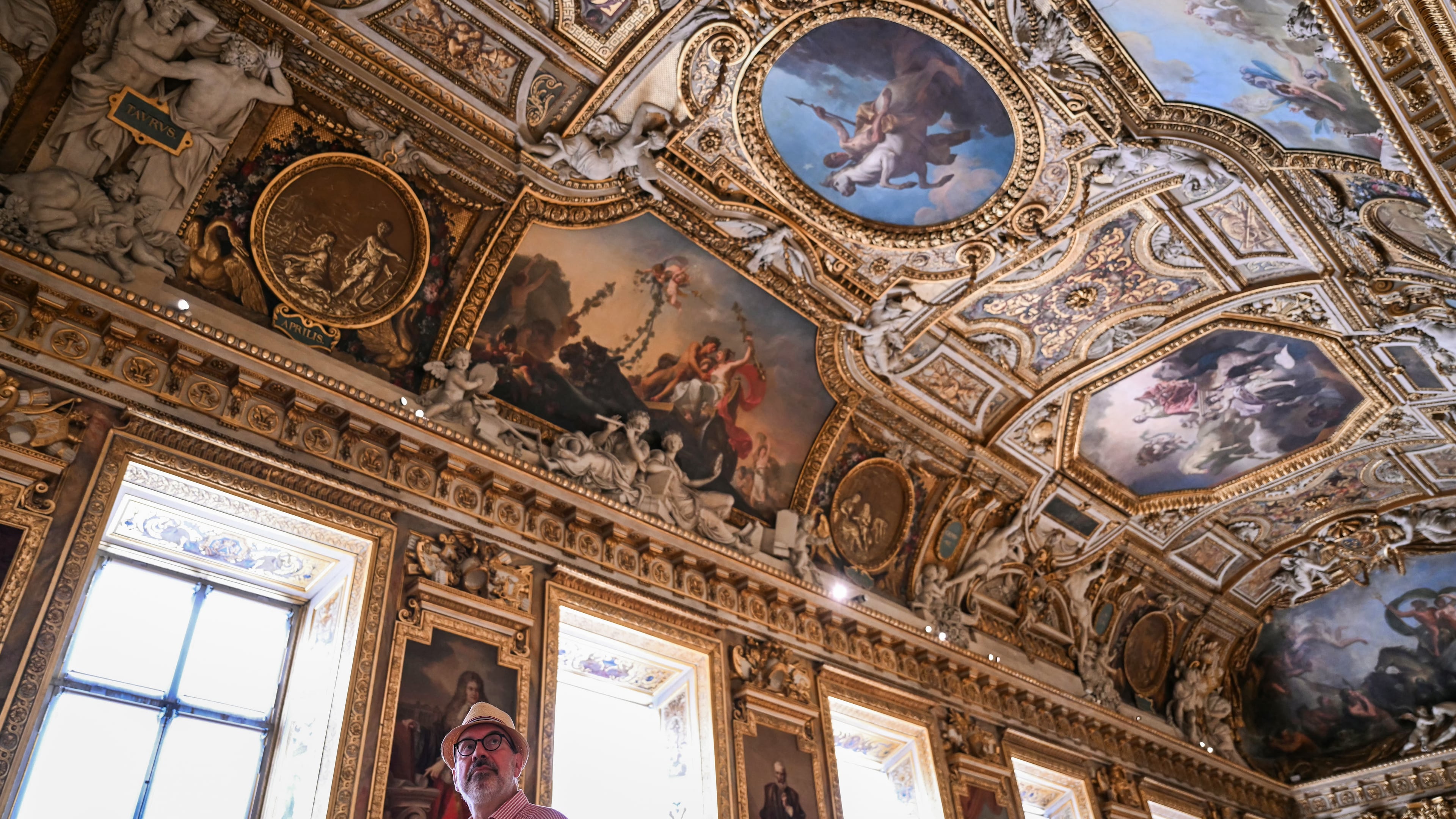 A visitor looks on during the reopening to the public of the Apollo Gallery, at the Louvre museum in Paris, Wednesday, July 22, 2026. (Lou Benoist/Pool Photo via AP)