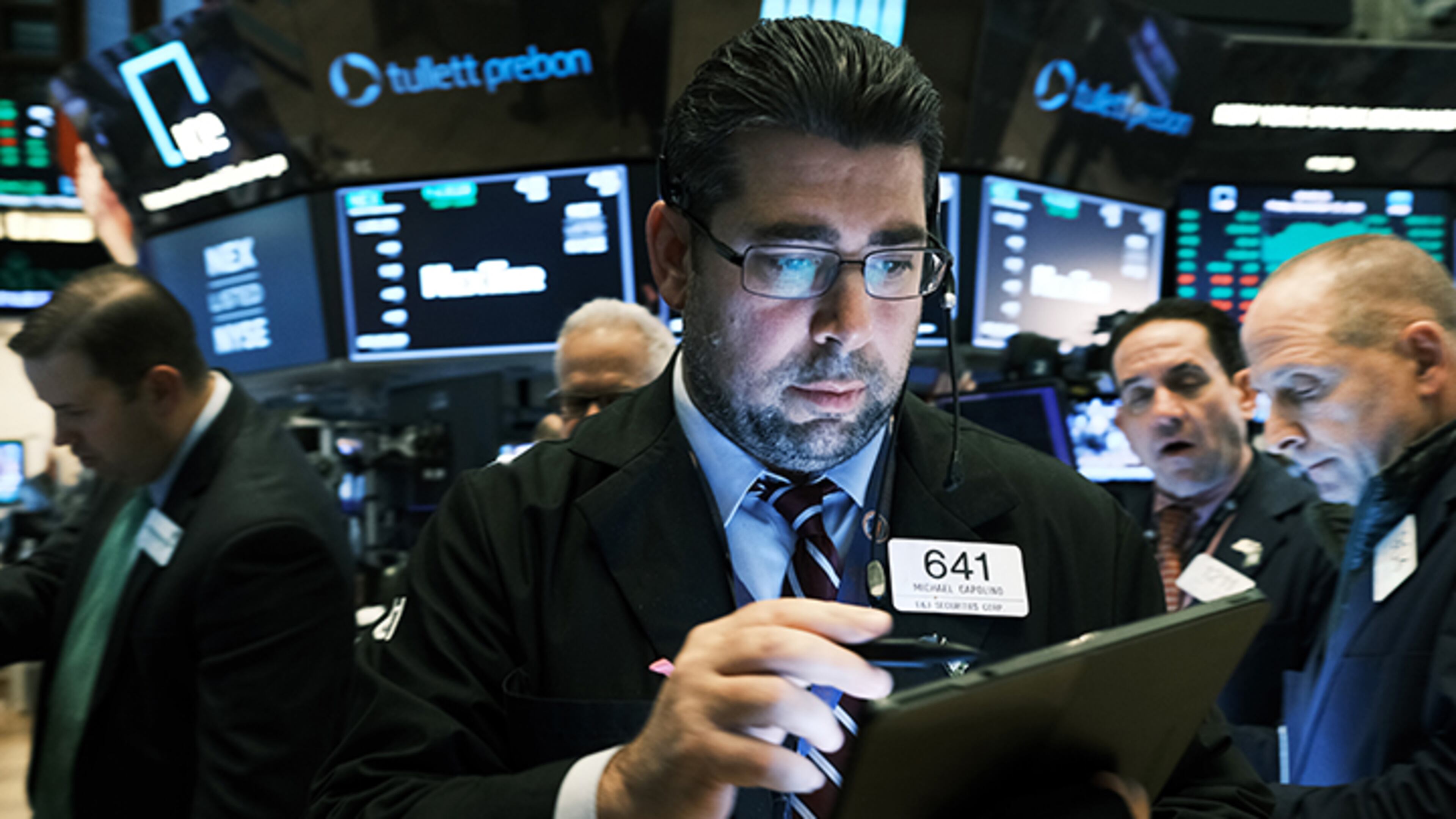 Traders work on the floor of the New York Stock Exchange Friday. As trade talks with China show some progress, the Dow Jones Industrial Average rose 222 points to close above 28, 000 for a new record.