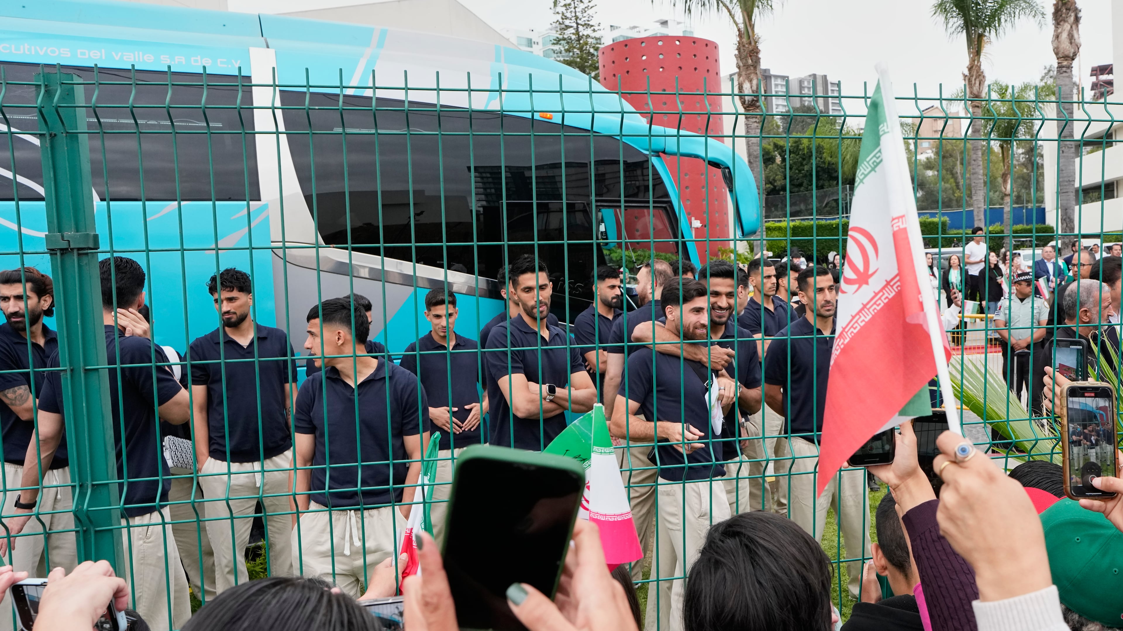 Fans greet members of the Iran World Cup soccer team as they leave their hotel for the airport Tuesday, June 30, 2026, in Tijuana, Mexico. (AP Photo/Gregory Bull)