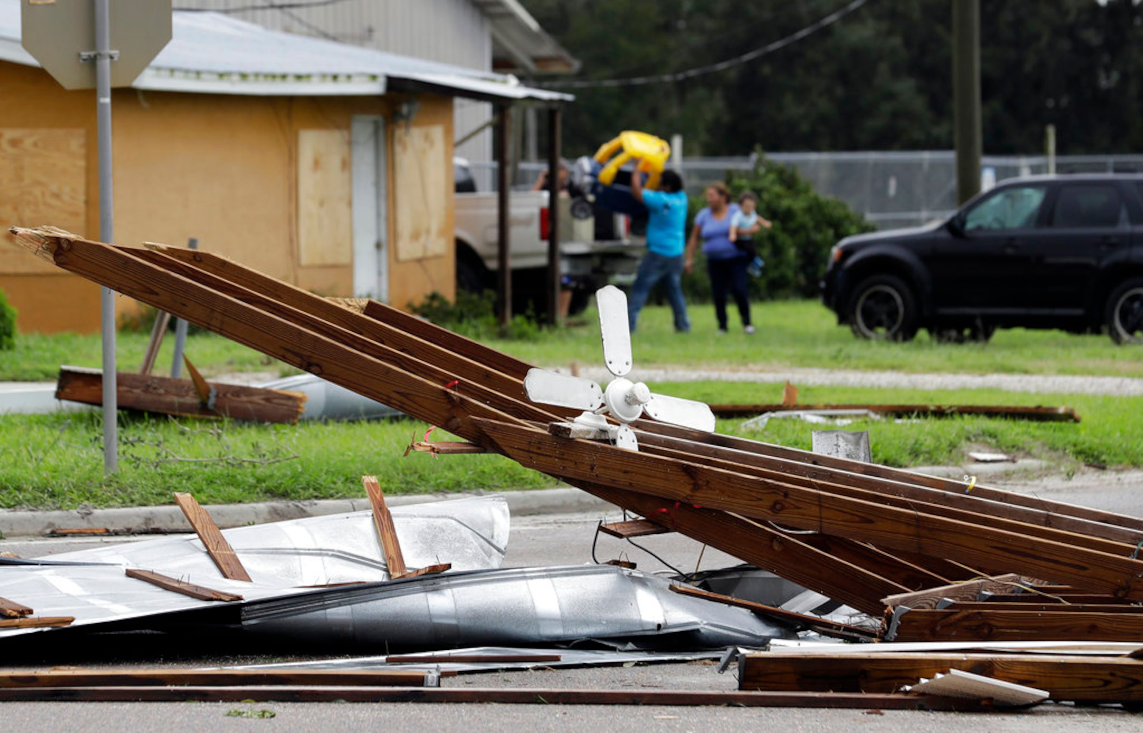 Residents salvage some of their property as their car port roof sits on U.S. 17 Monday, Sept. 11, 2017, in Bowling Green, Fla. The eye of Hurricane Irma passed over the area earlier this morning. (AP Photo/Chris O'Meara)