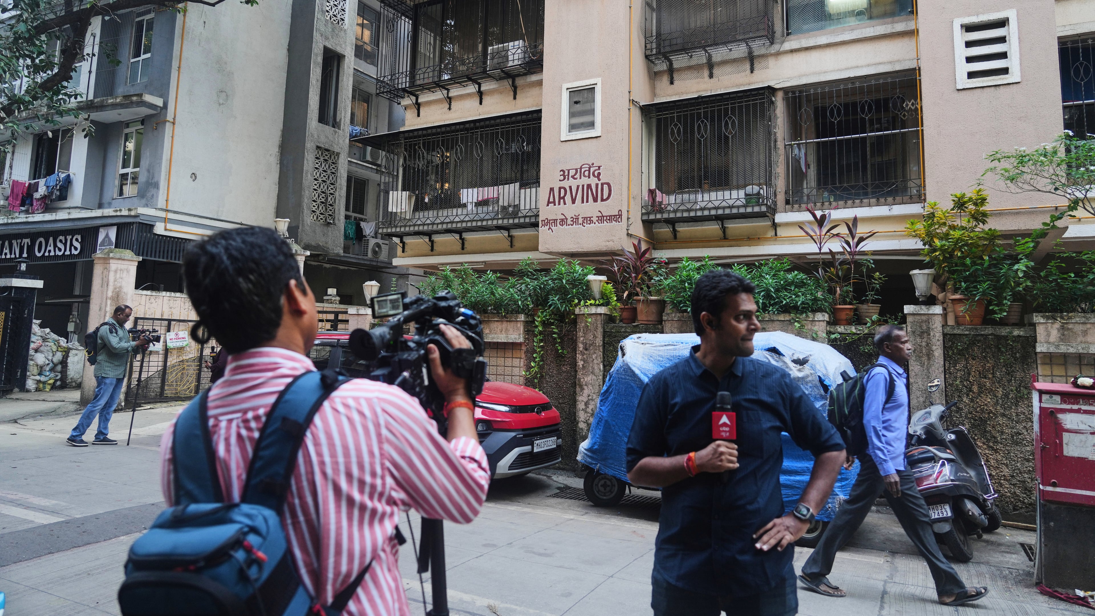 News media personnel stand outside the building where relatives of Smit Machchhar, an Indian pilot for Flydubai, previously lived in Mumbai, India, Thursday, Oct. 1, 2026. (AP Photo/Rafiq Maqbool)