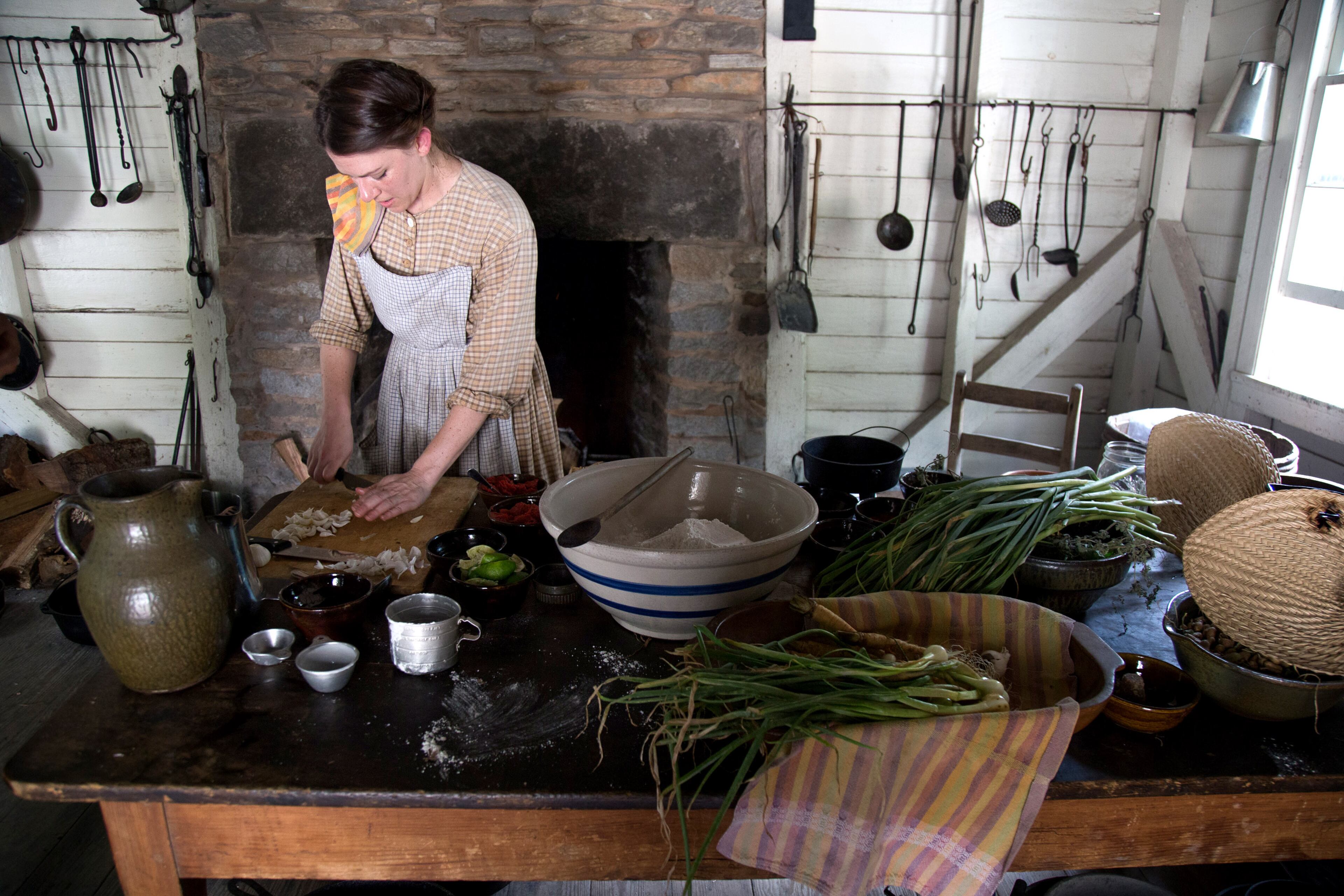 Museum interpreter Kat Kovak prepares food for the Barbecue Nation Cooking Demonstration during the Juneteenth program that focuses on the appreciation and commemoration of the end of slavery in the United States Sunday, June 17, 2018, at the Atlanta History Center. STEVE SCHAEFER / SPECIAL TO THE AJC