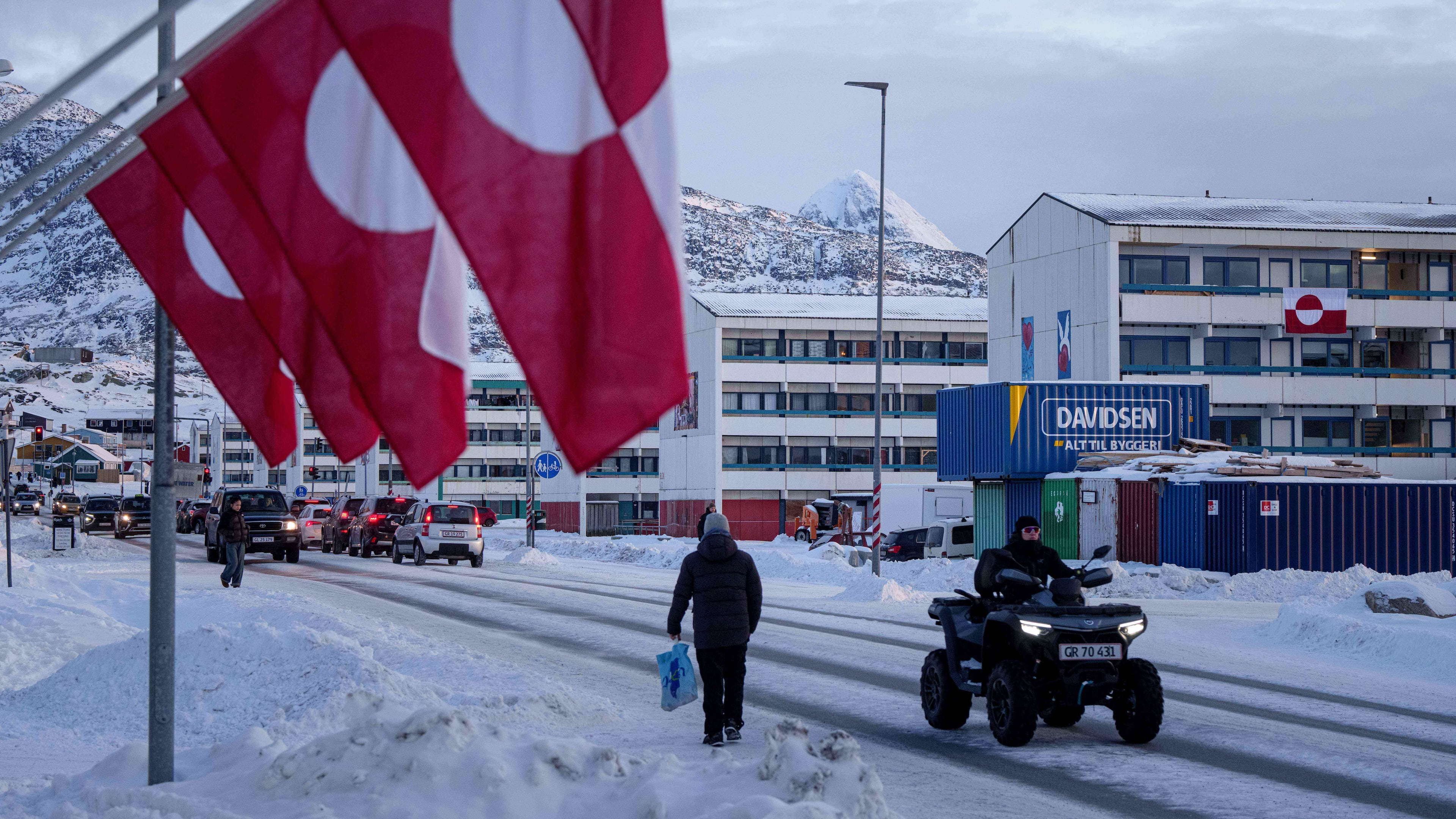 A man rides by on a quad bike past a row of Greenlandic national flags in Nuuk, Greenland, Wednesday, Jan. 14, 2026. (AP Photo/Evgeniy Maloletka)