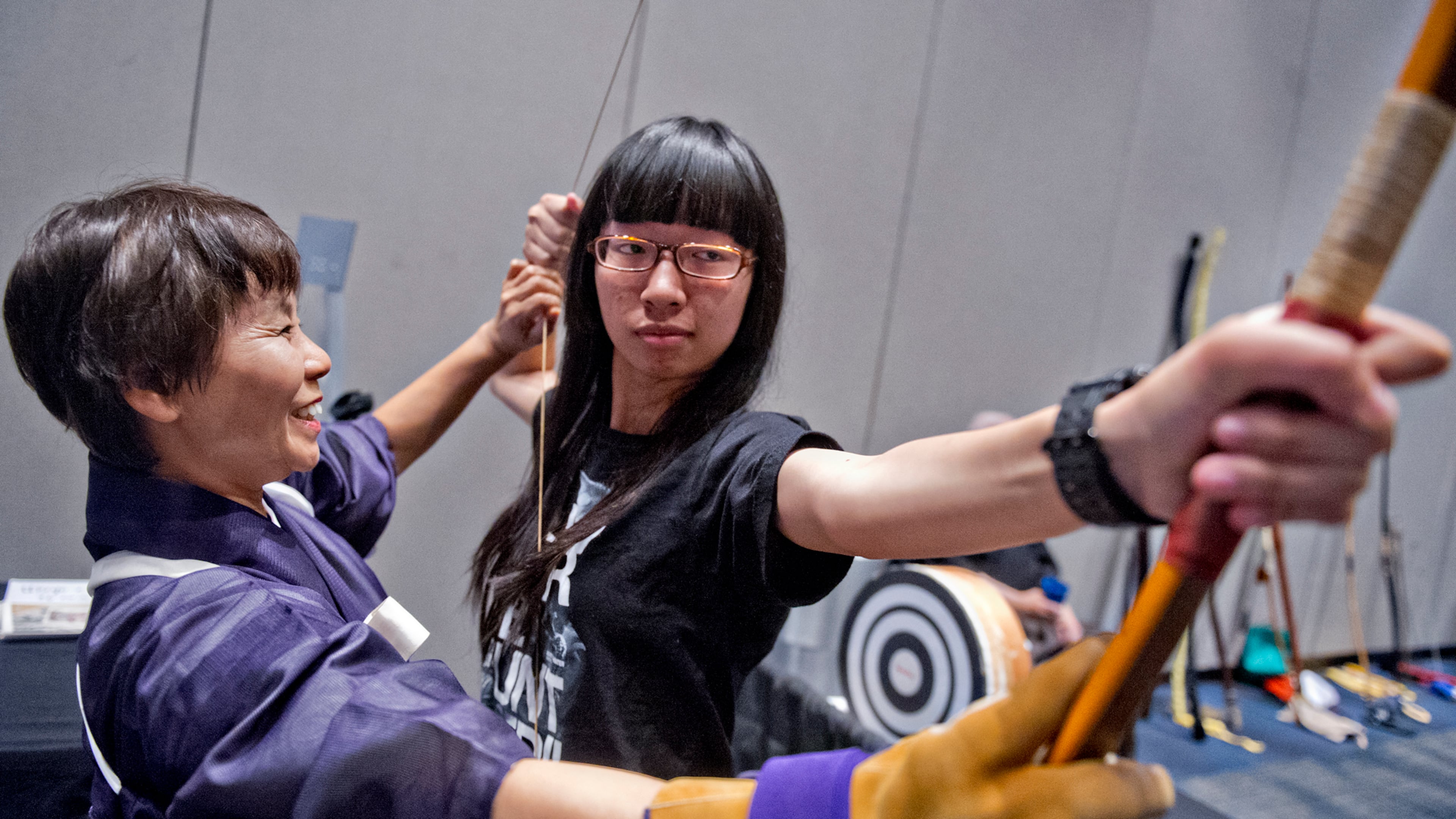 Reiko Blackwell (left) shows Ailin Yang the proper way to draw a traditional Japanese bow during the 2014 JapanFest at the Gwinnett Center in Duluth on Saturday, September 20, 2014. The 28th annual weekend long festival celebrated everything Japan with demonstrations, crafts, performances and vendors selling food and goods. JONATHAN PHILLIPS / SPECIAL
