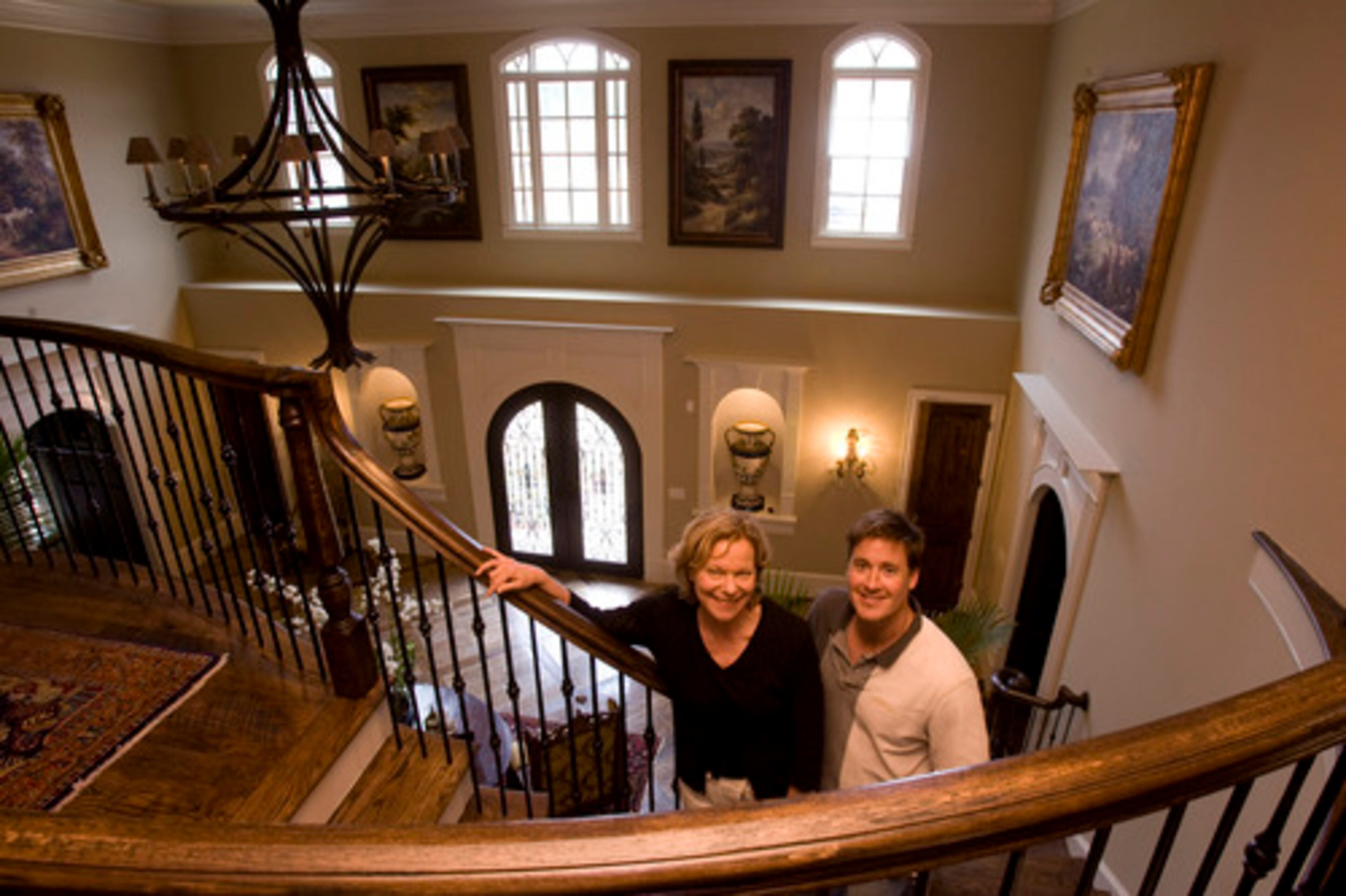 Tweedie Griswold (from left,) the 2008 Showhouse home tour chairperson, and Jason Rosen, builder, stand on the steps of the grand foyer of Canton Place. The foyer was designed by Peter Brandi Gallery & Interiors.