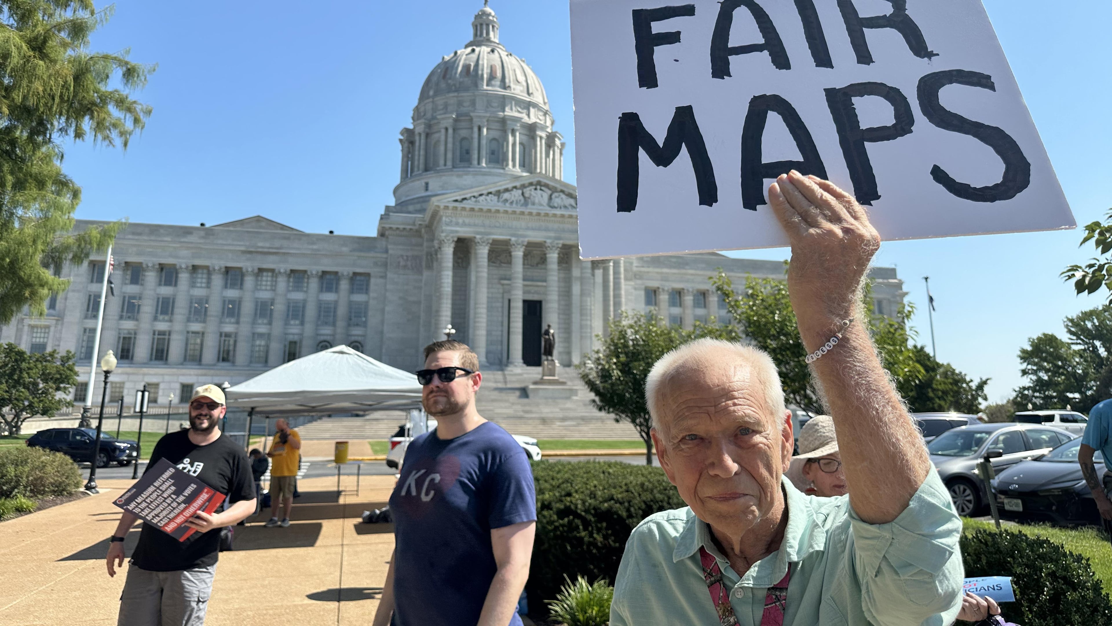 This photo taken with a smartphone shows Steve Perry, of Kansas City, holding a sign in opposition to Missouri’s congressional redistricting plan on Wednesday, Sept. 2, 2026, outside the state Capitol, in Jefferson City, Mo. (AP Photo/David A. Lieb)