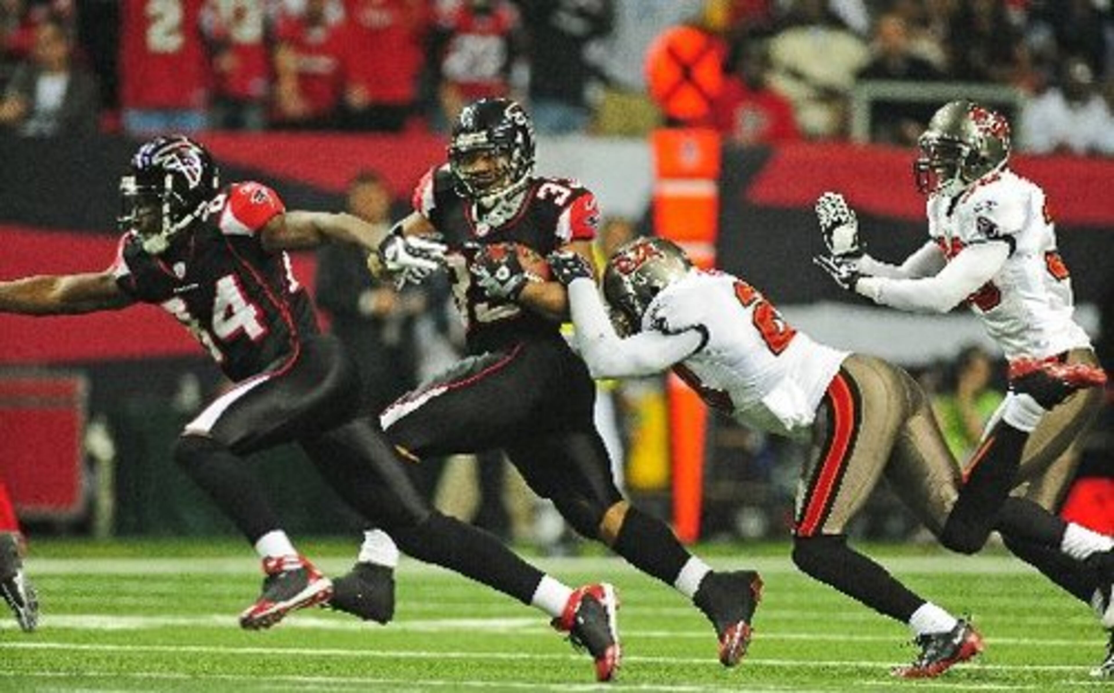 Turner sheds a tackle during one of his longer runs of the day as Roddy White looks to throw a block.