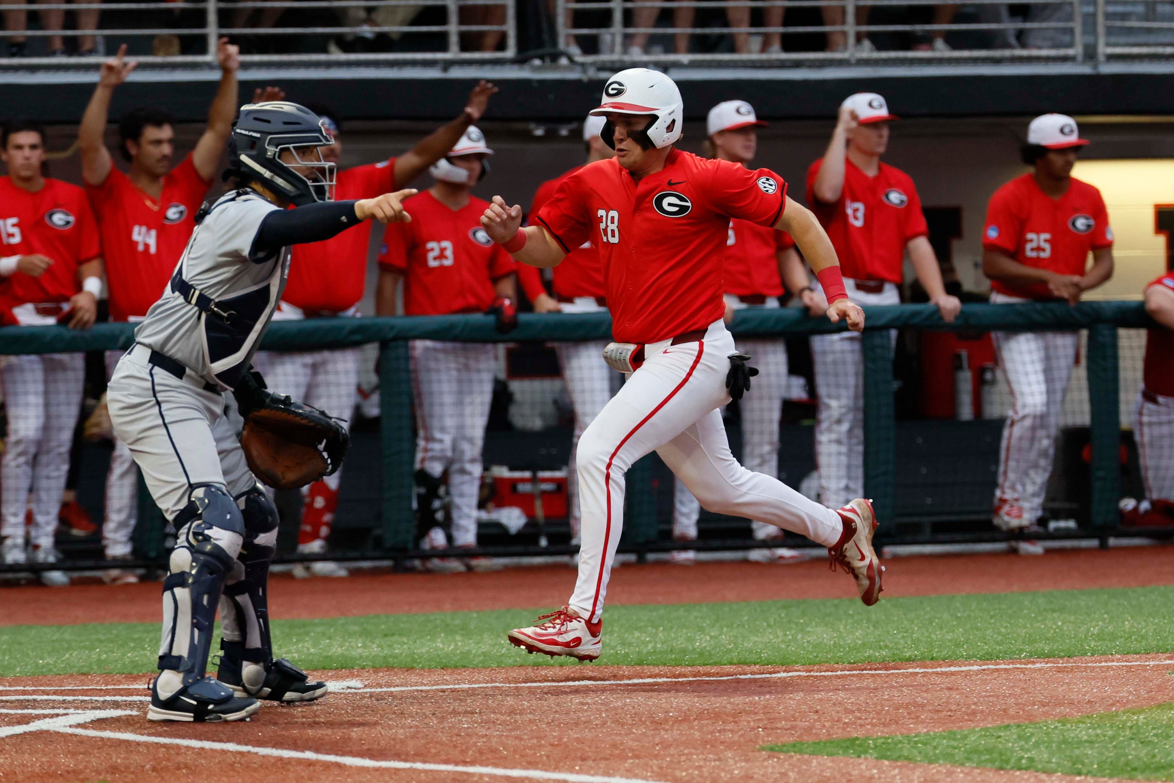 Georgia Bulldogs catcher Brennan Hudson (28) scores on a two-RBI single from Georgia Bulldogs infielder Ryan Wynn (0) in the eighth inning of the NCAA Regional final at Foley Field on Sunday, May 31, 2026, in Athens. (Miguel Martinez/AJC)