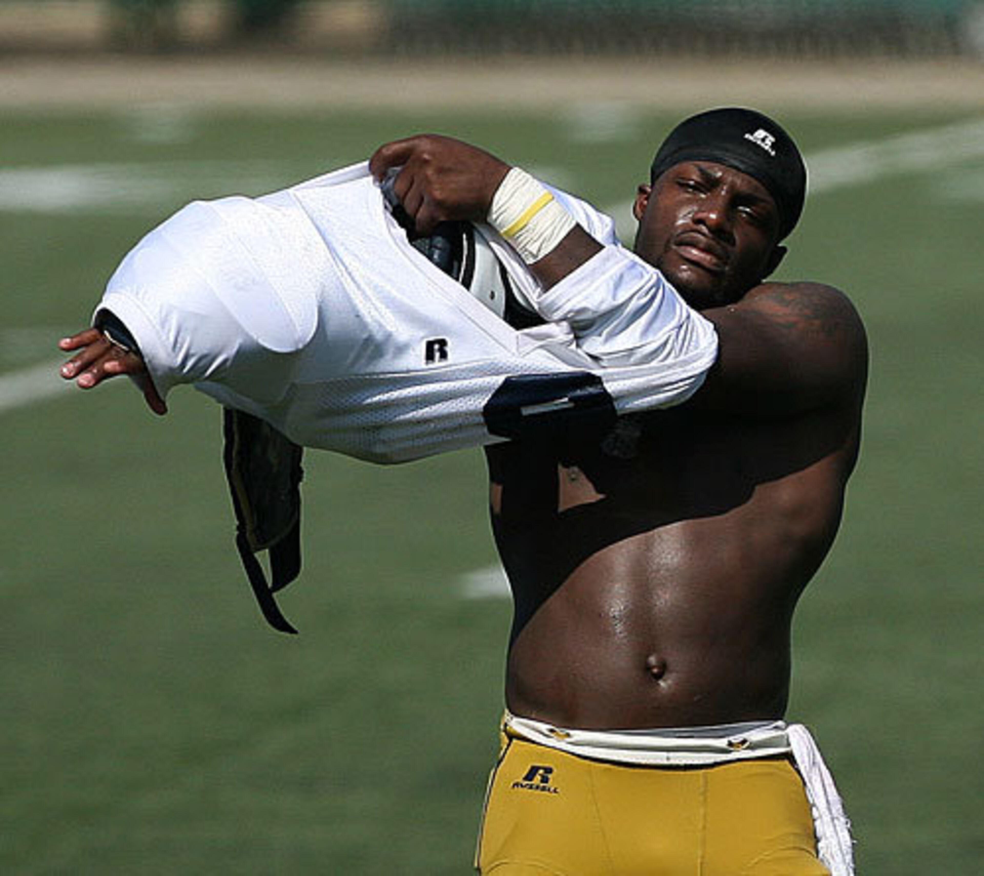 Quarterback Josh Nesbitt puts on his pads as temperatures climb.