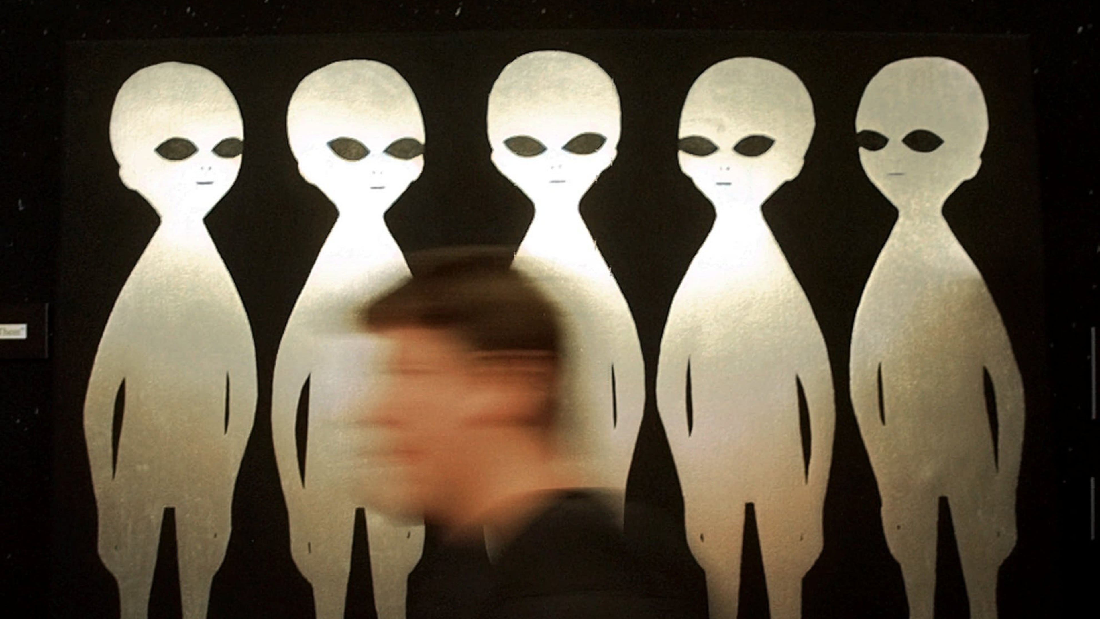 FILE - A patron passes a painting inside the International UFO Museum and Research Center in Roswell, N.M., on June 10, 1997. (AP Photo/Eric Draper, File)
