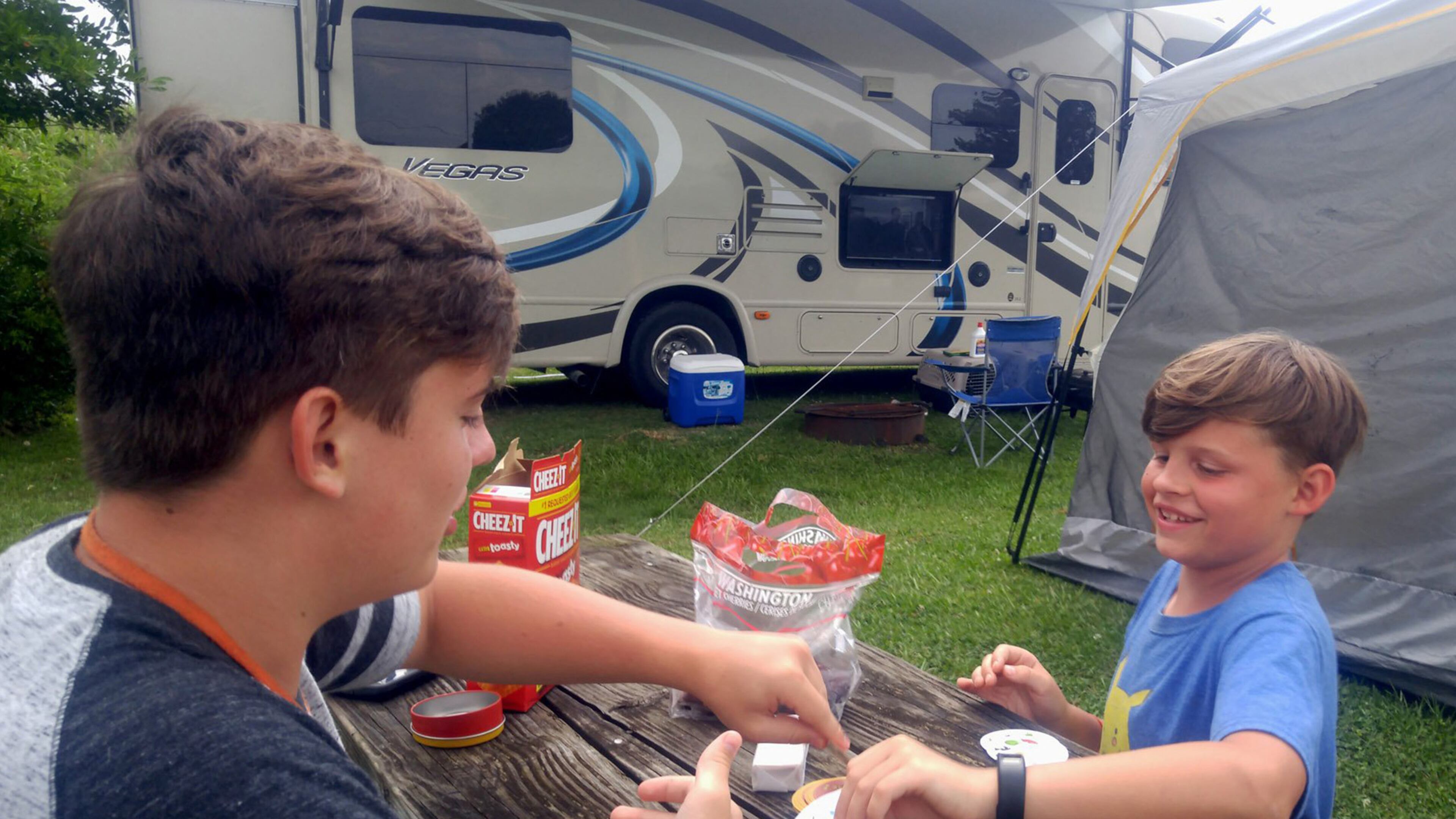 Maxwell Franck, left, and Jackson Franck, right, play a game of cards near their air conditioned tent at Lanier's Campground in Holly Ridge, N.C. The RV in the background has a flatscreen TV on its exterior. (Matthew Franck/St. Louis Post-Dispatch/TNS)