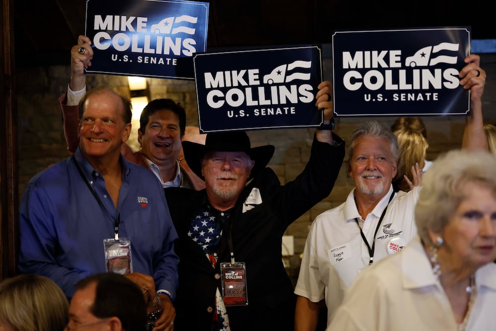 Supporters of U.S. Rep. Mike Collins hold banners during an runoff election night watch last month at Seven Oaks Manor in Jackson. (Miguel Martinez/AJC)