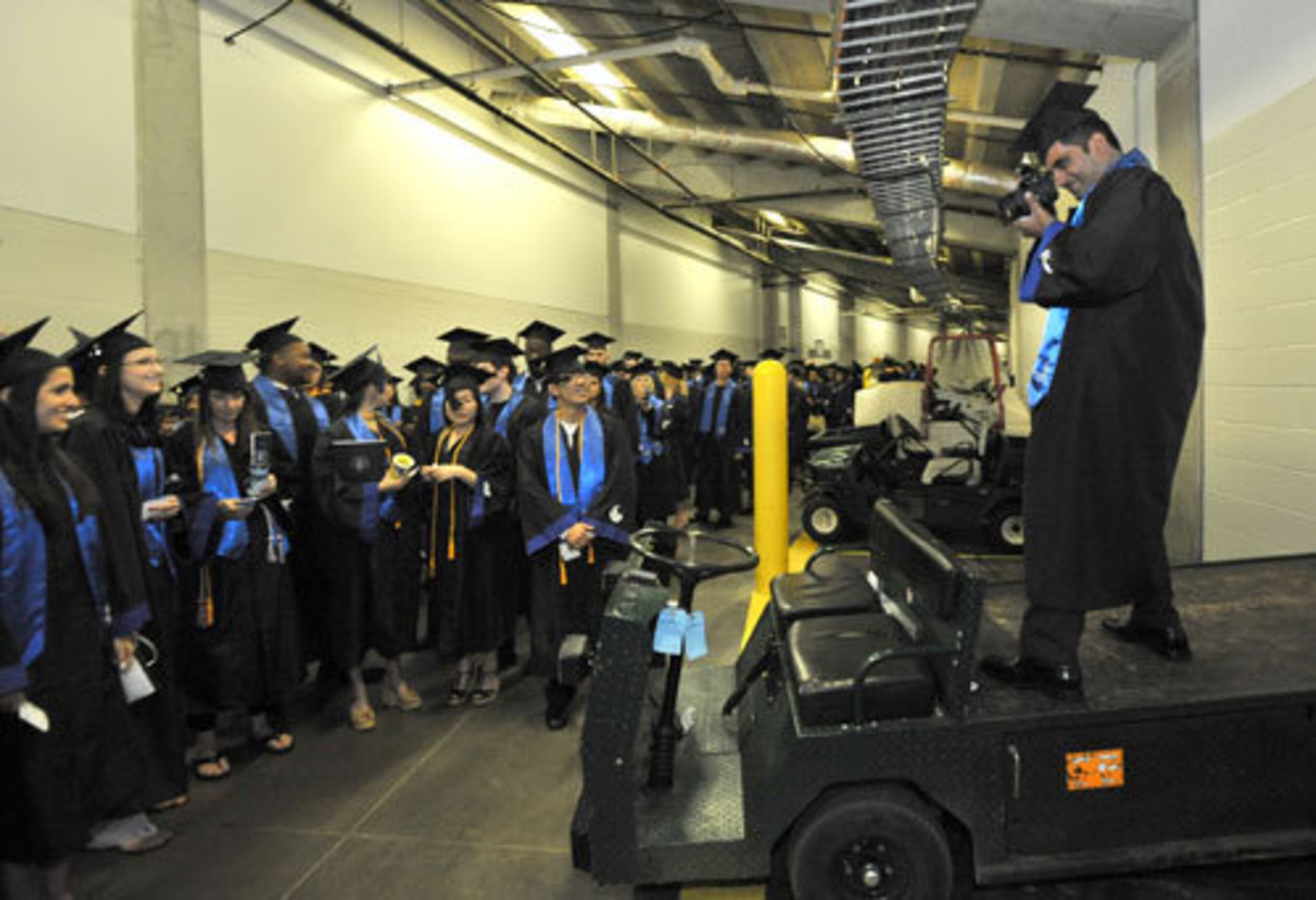 Irfan Ali, right, Economic and Finance major, takes a picture of his classmates before ceremony begins.