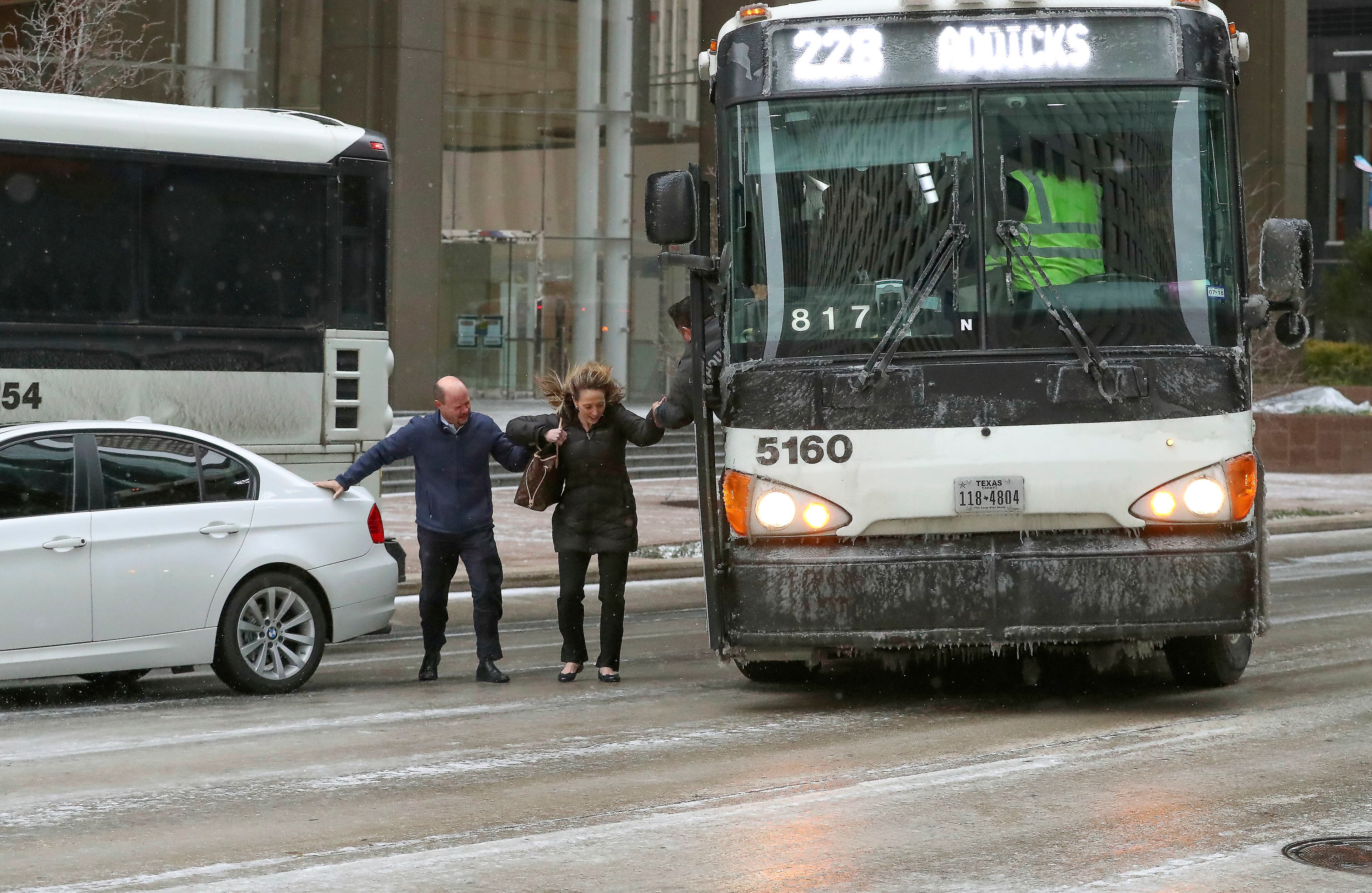 After a pair of Metro buses became disabled, commuters fight the elements to board another bus at McKinney St., and Louisiana St., Tuesday, Jan. 16, 2018, in Houston. ( Steve Gonzales/Houston Chronicle via AP)