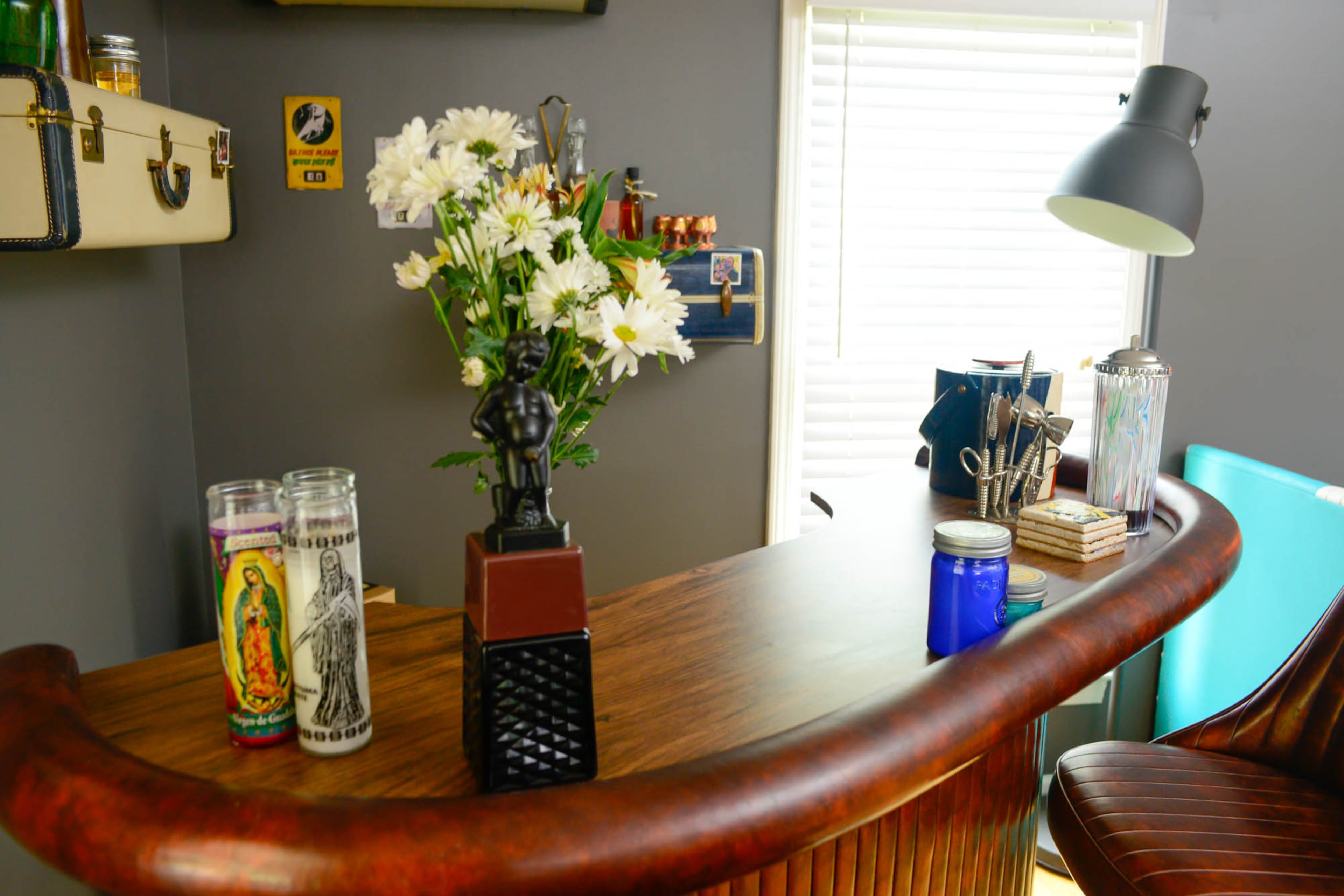 A vintage bar from Highland Row Antiques is a sophisticated counterbalance to the eclectic elements in the living room.